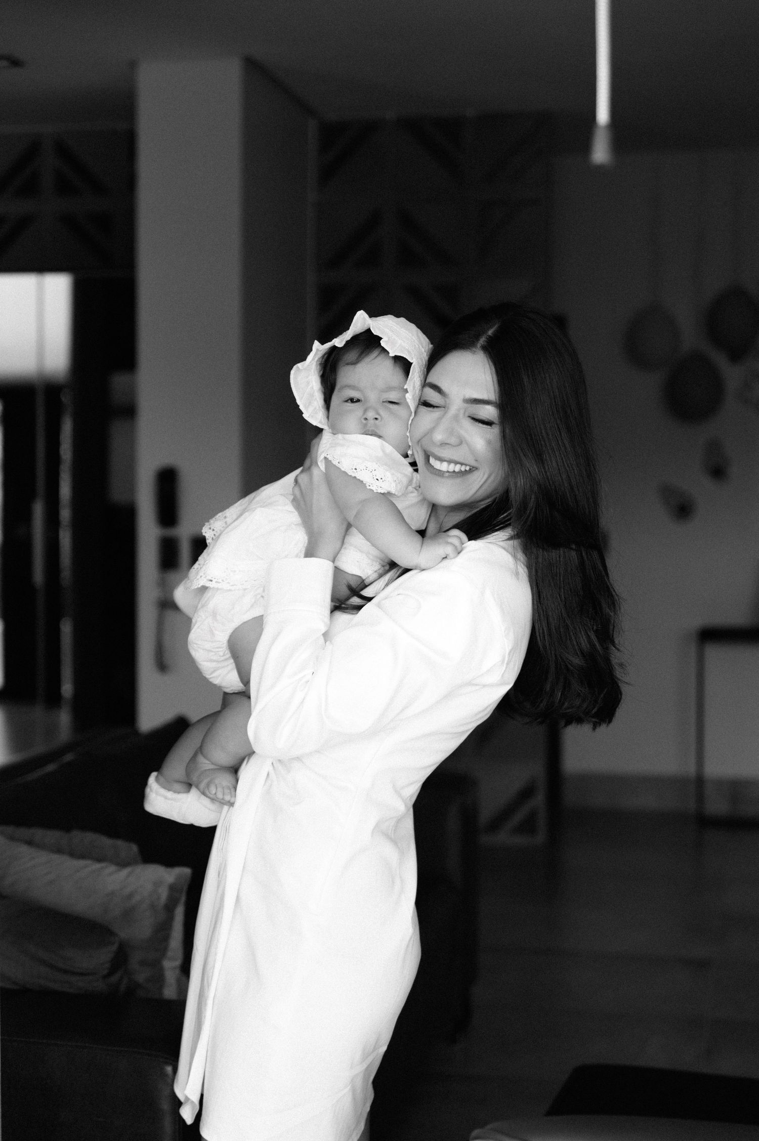 A series of black and white photos showing two people embracing and laughing together in an indoor setting.