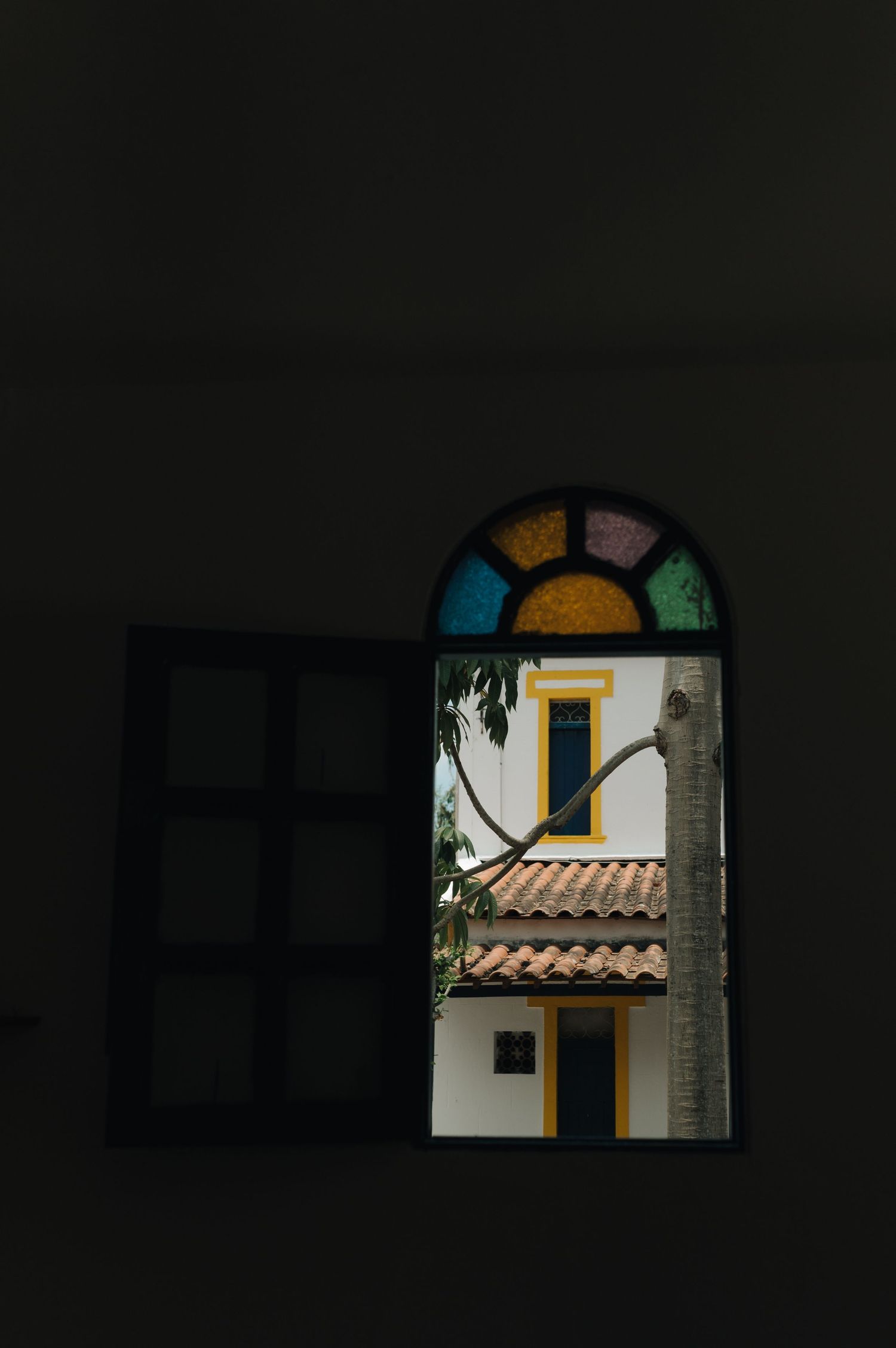 View through a stained glass window showing yellow and blue architectural details.