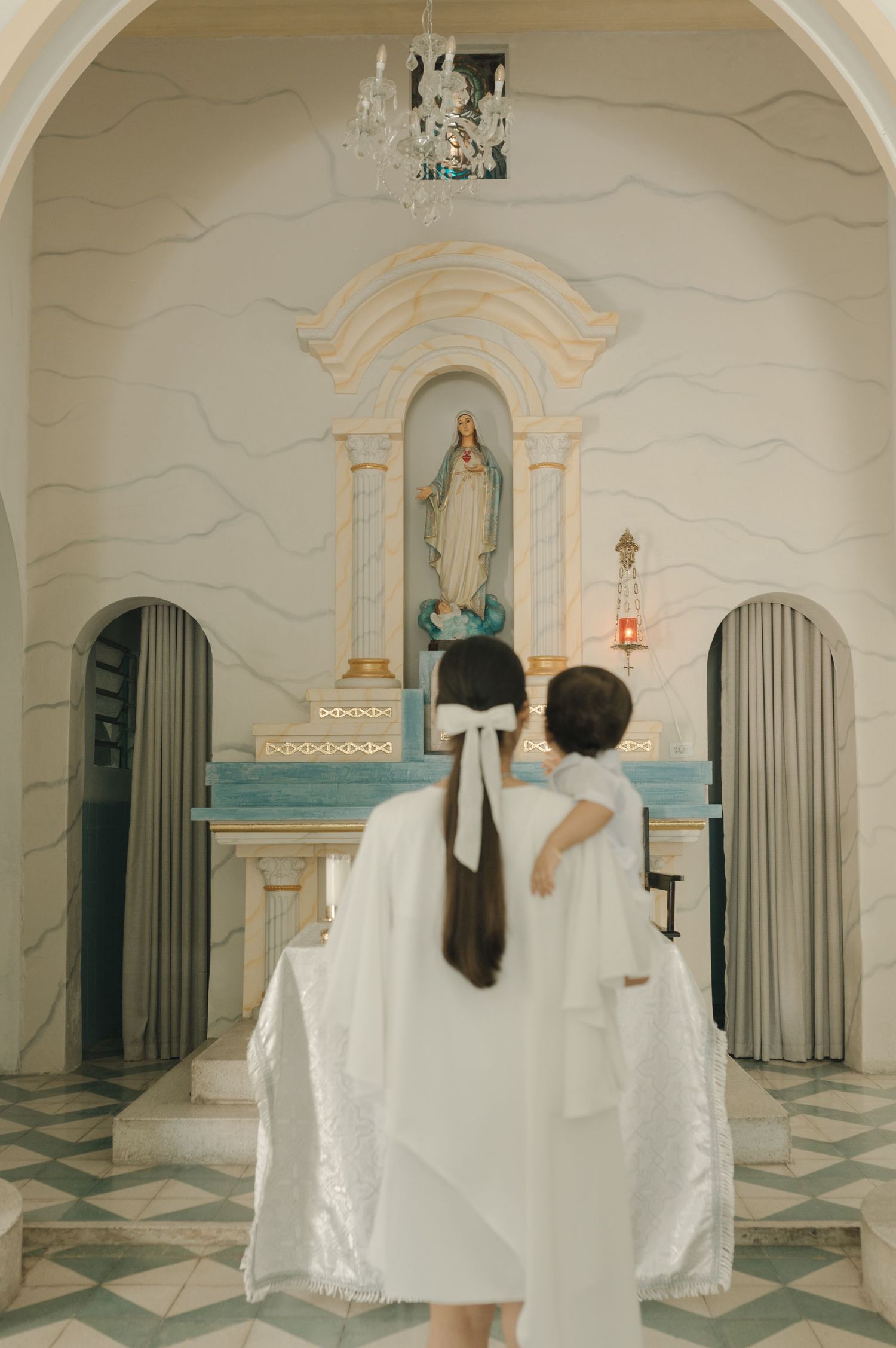A series of four photos showing a couple in white outfits dancing in an elegant white and blue palace-like interior space.