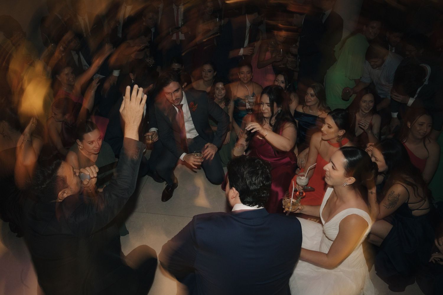 Wedding celebration showing a lively dance floor with guests enjoying themselves in warm lighting.