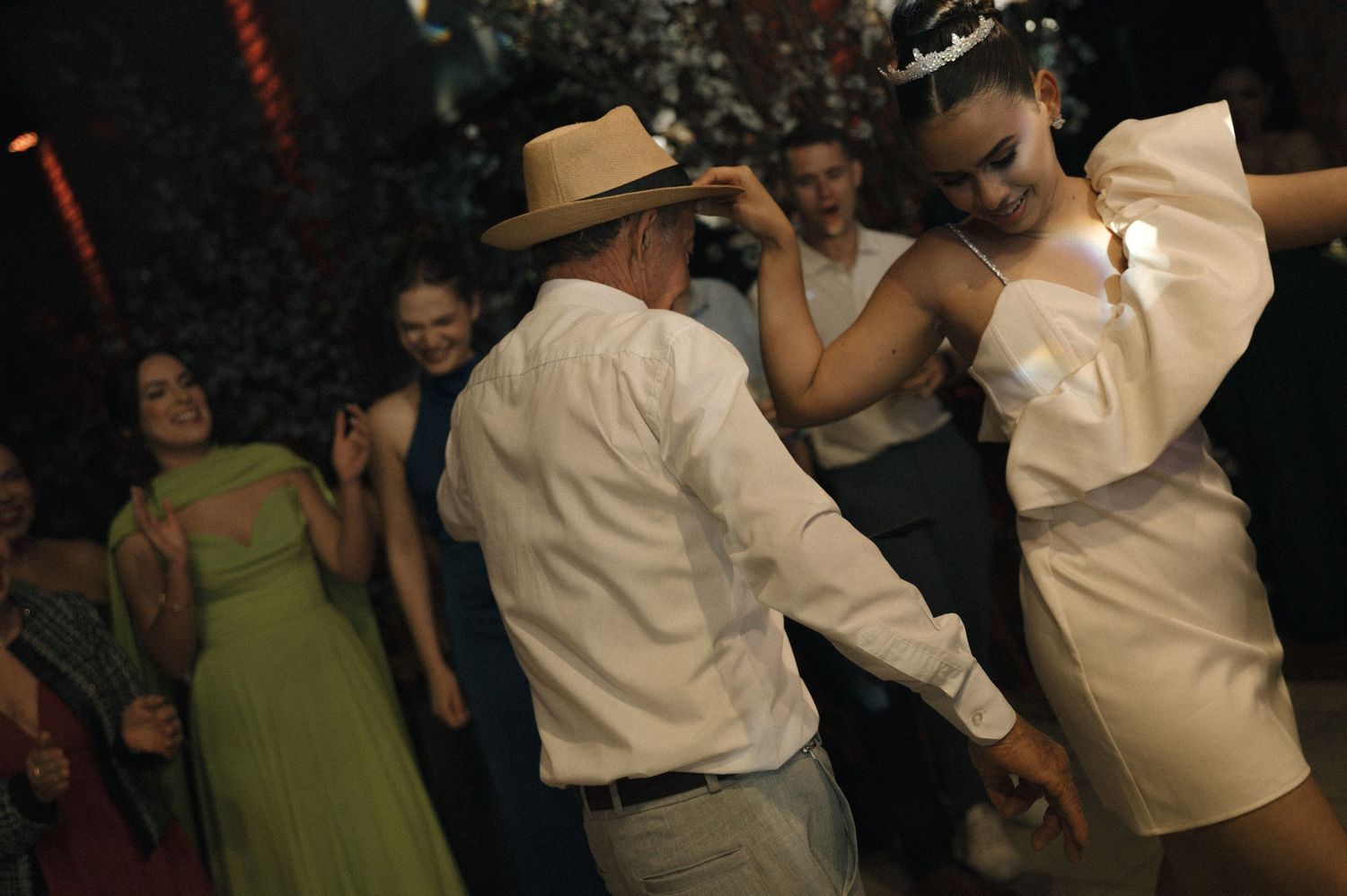 Couples dancing together at a wedding reception with people wearing formal attire.