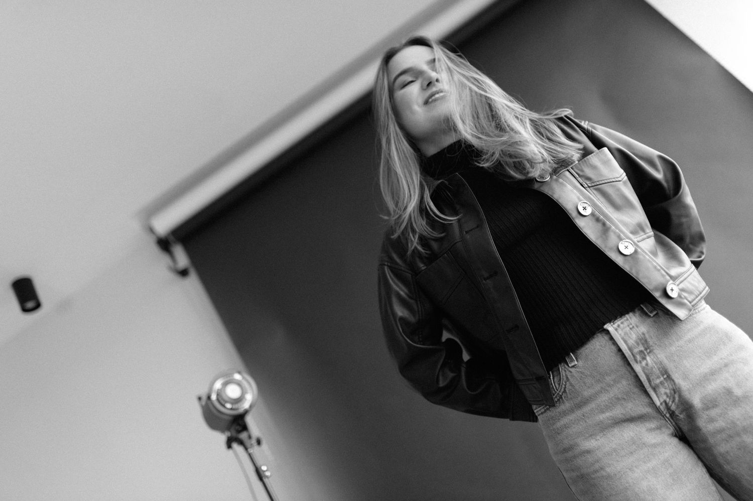 Low angle black and white shot featuring casual denim and leather jacket.
