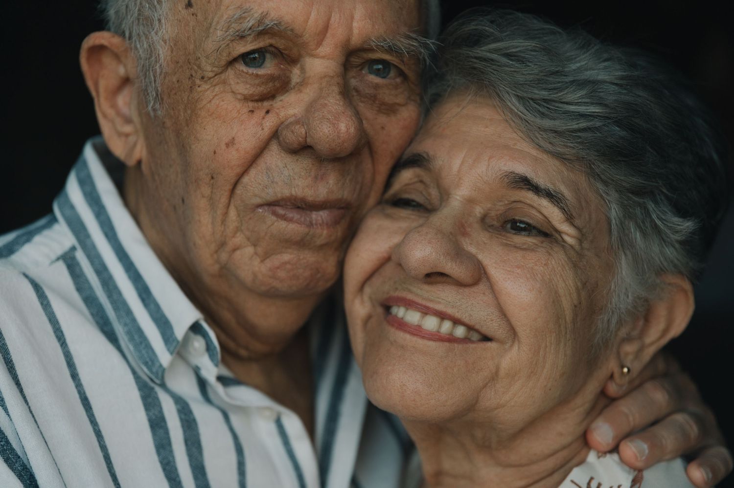 An elderly couple shares tender moments together in a series of black and white photographs showing their affection.