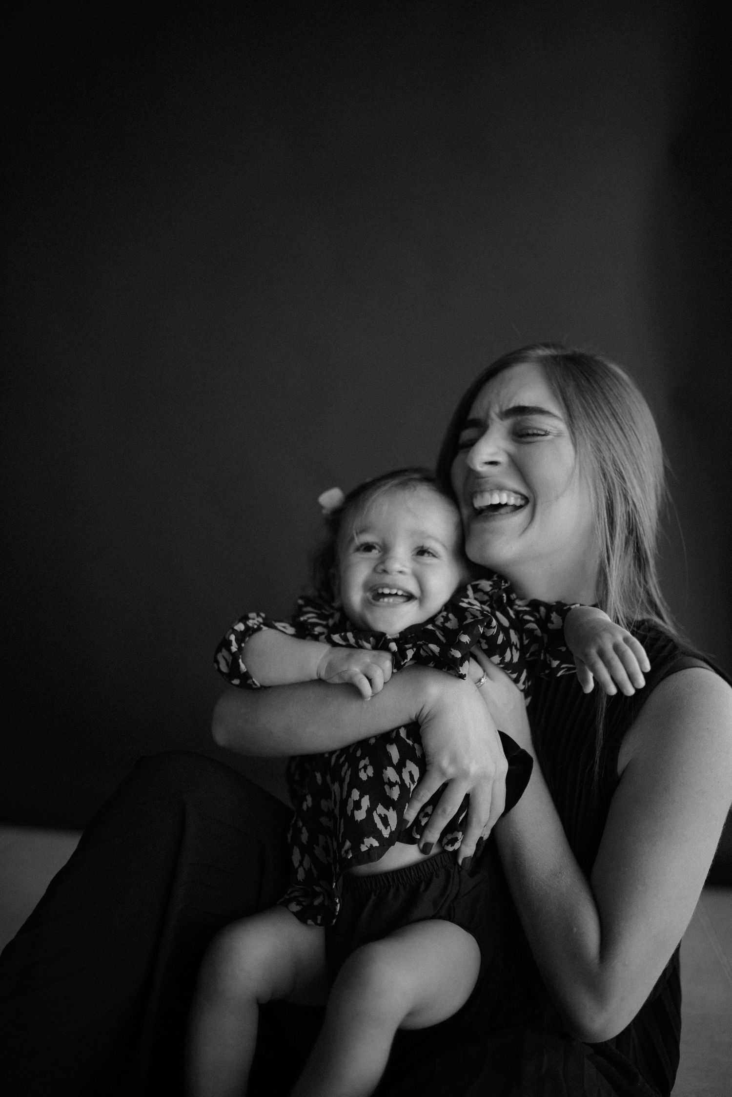 Joyful candid black and white portrait capturing pure laughter and cuddles.