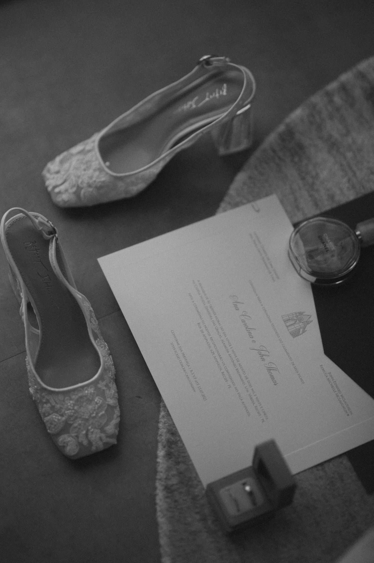 Vintage ballet slippers and paper documents arranged in a black and white artistic composition.
