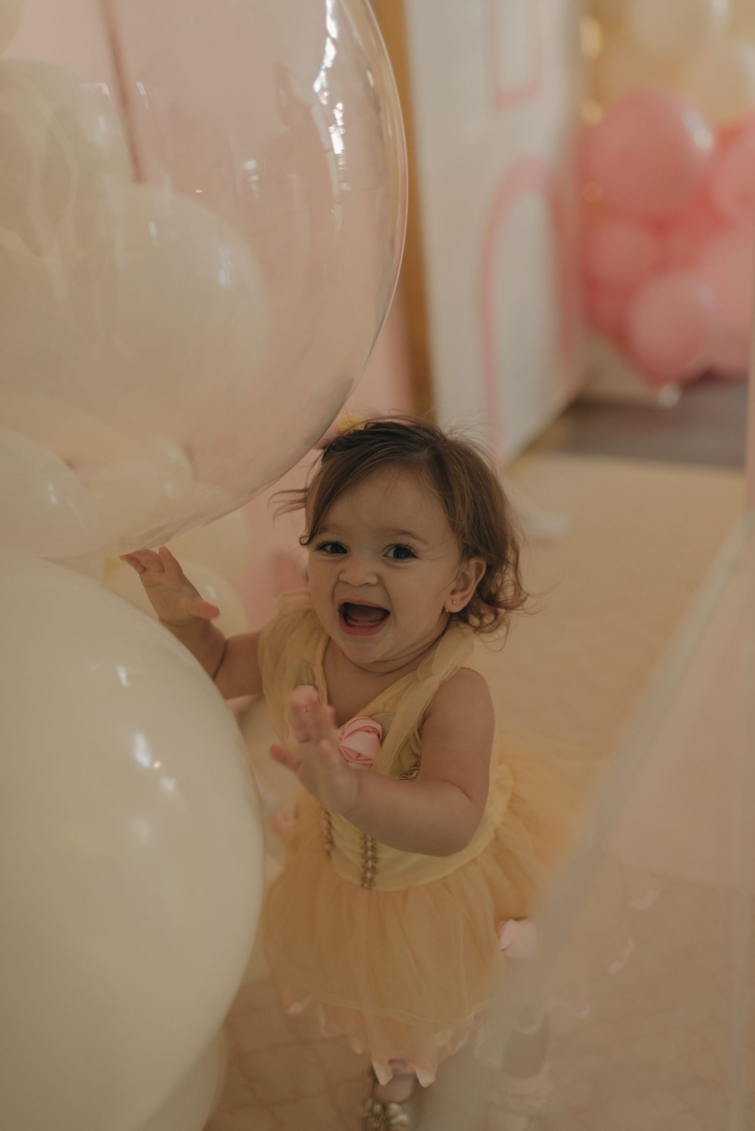 A joyful celebration moment with white balloons and soft lighting.