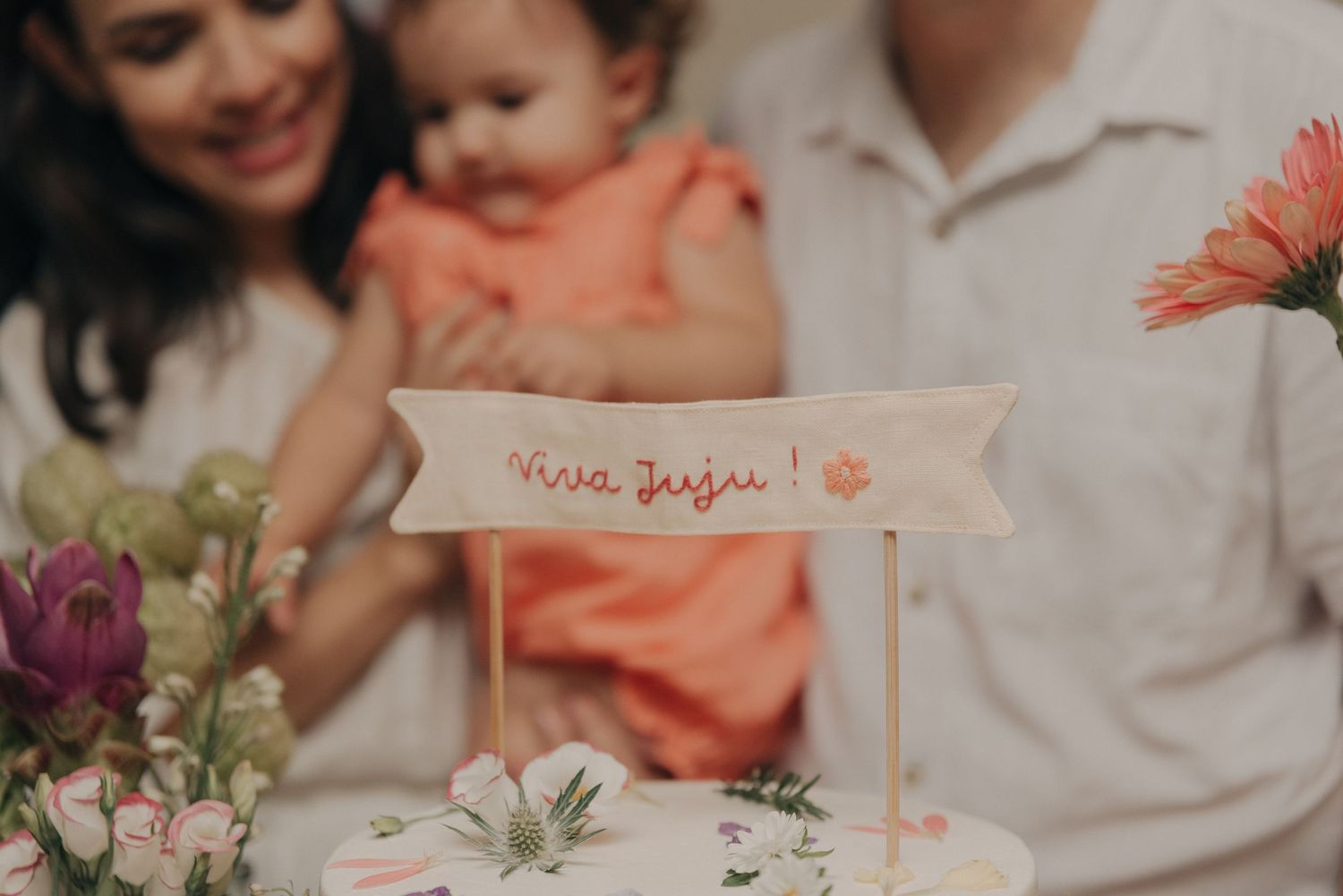 Soft focus photo of a table setting with flowers and a banner at a celebration.