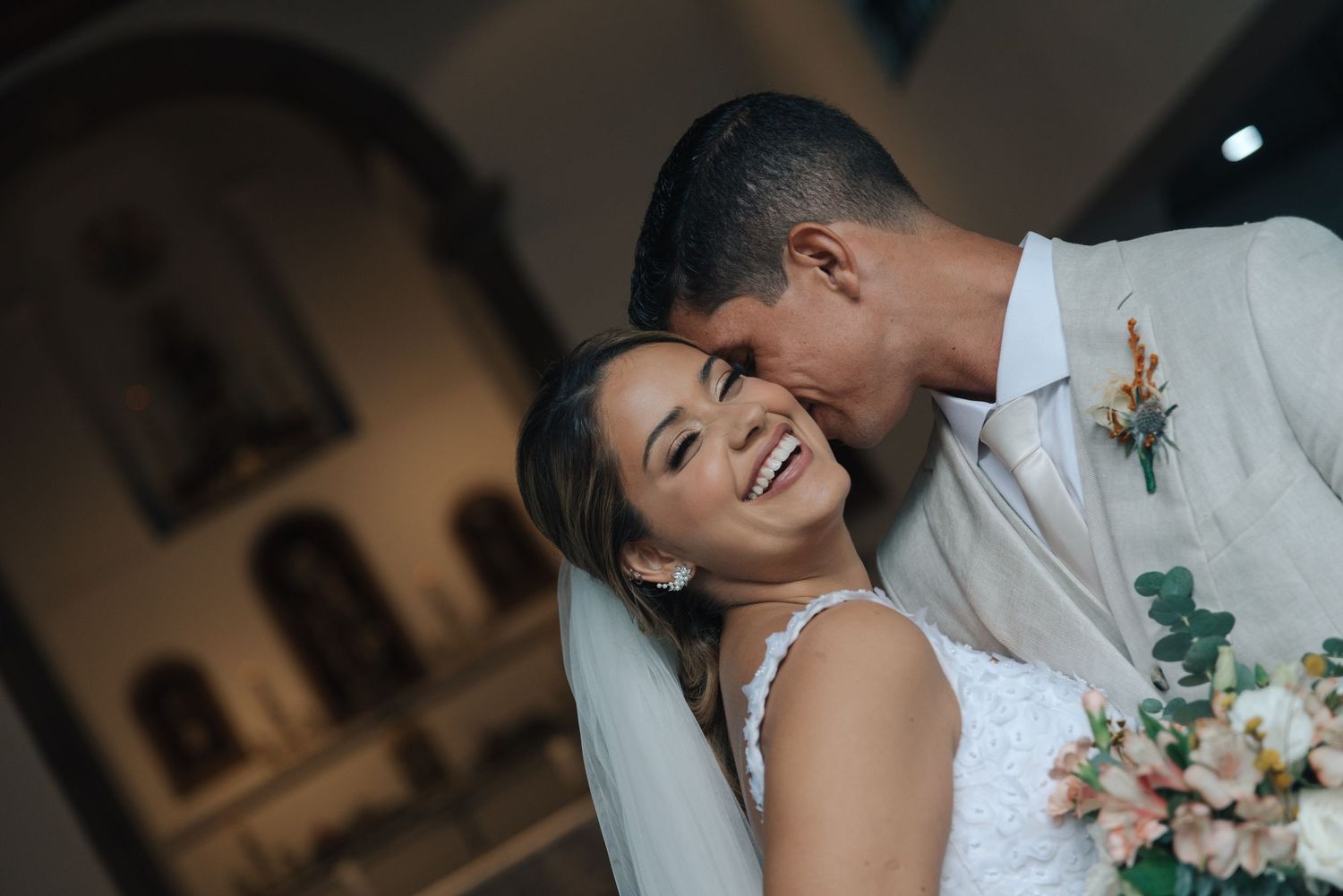 Intimate moment between newlyweds at wedding with bouquet and boutonniere.