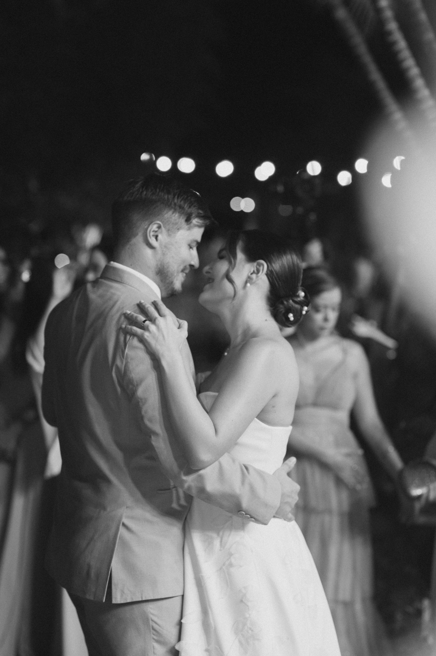 Romantic first dance at wedding reception with soft bokeh lights.