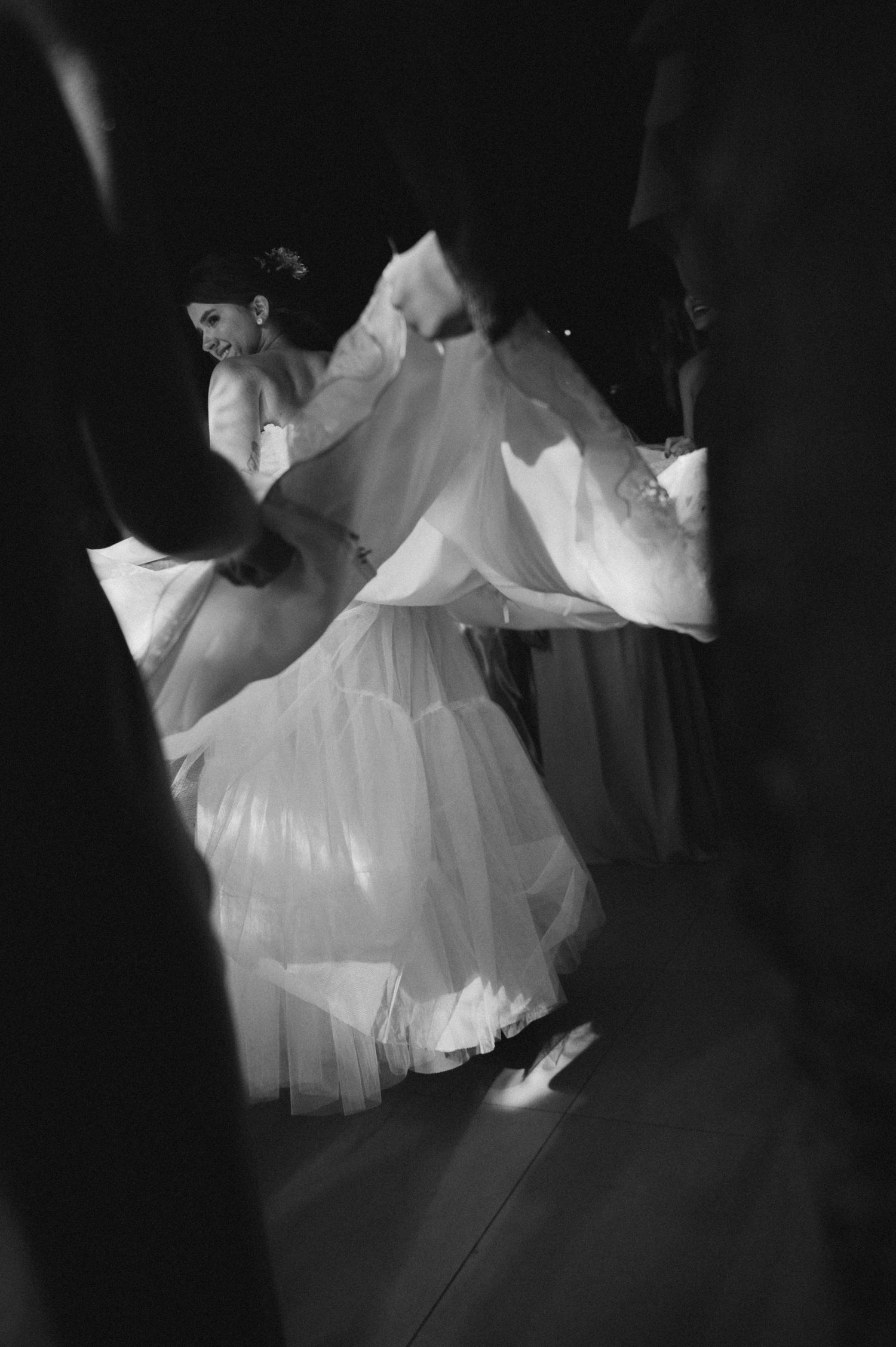 A black and white series of ethereal white dress movements captured in a darkened space creating a ghostly effect.