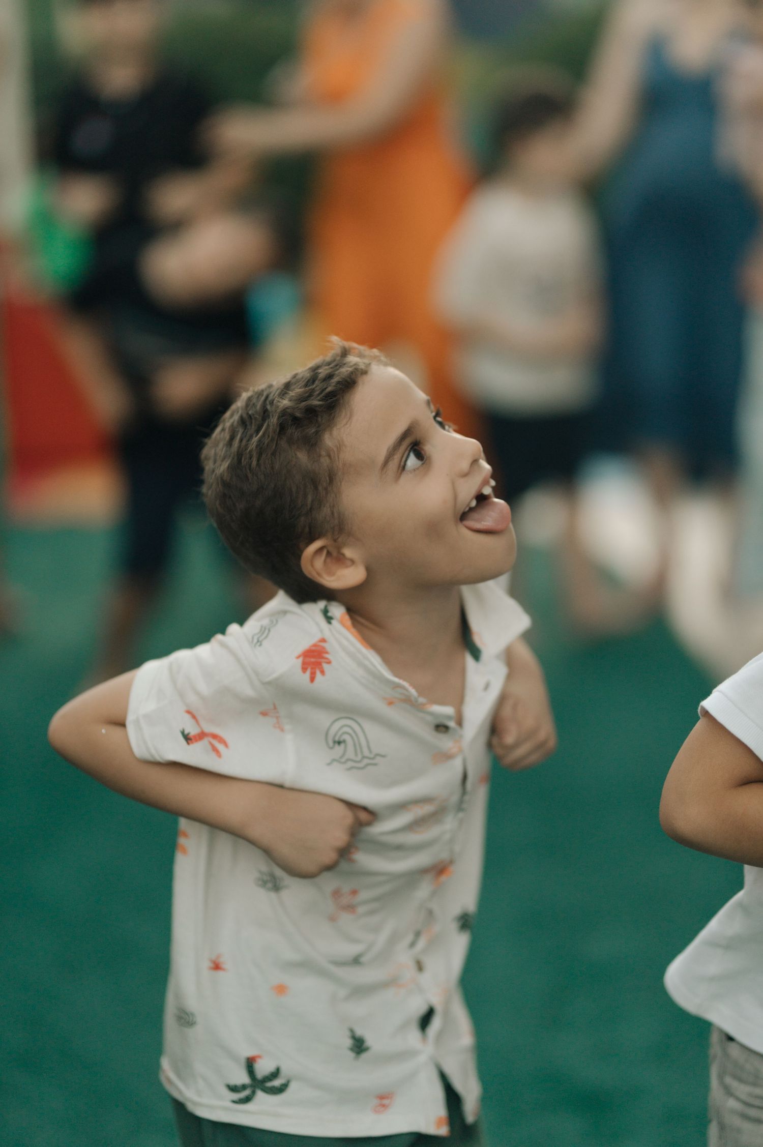 Young child looking up with excitement while playing on green turf.