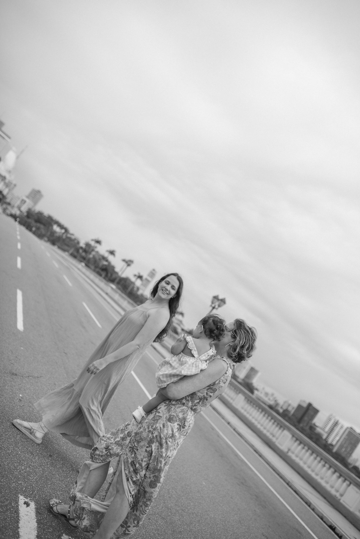 People enjoying a moment together on an empty road with cityscape in background.