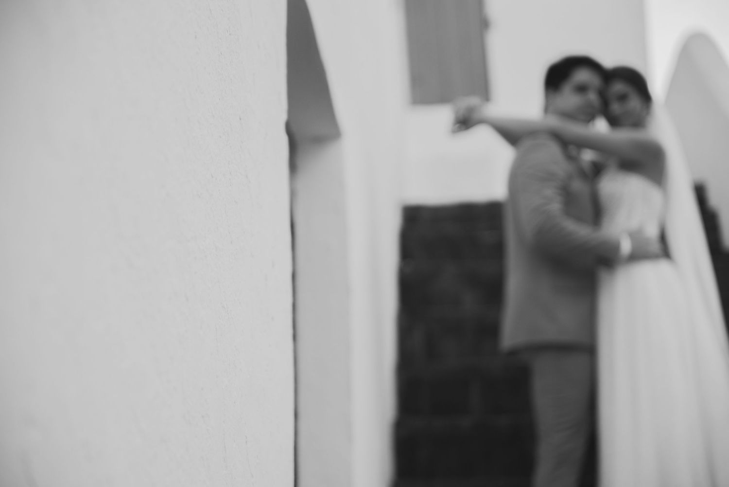 Soft focus black and white wedding photo of couple embracing.