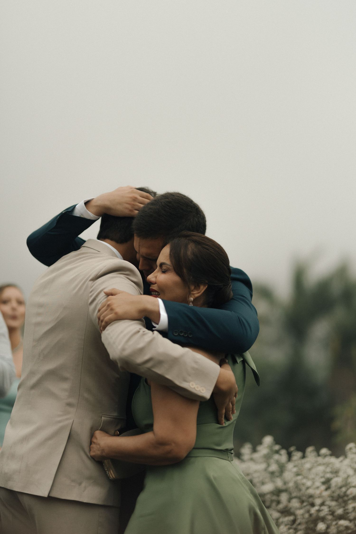 Three sequential photos showing an intimate embrace between two people in formal attire outdoors.