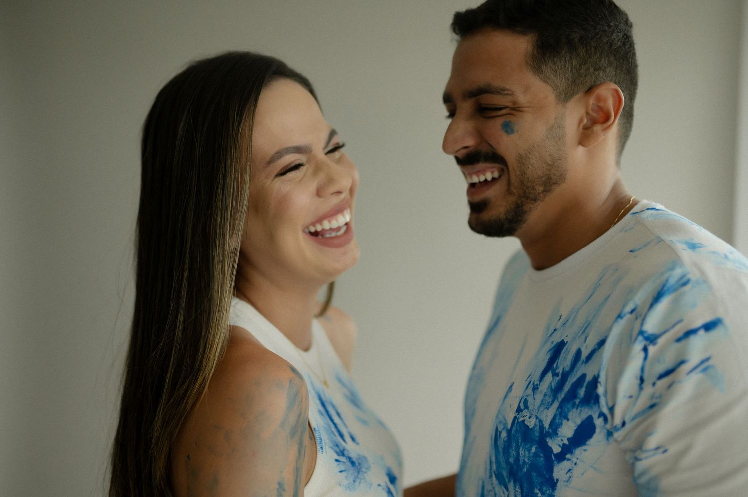A couple shares joyful laughter together during an intimate photoshoot session.