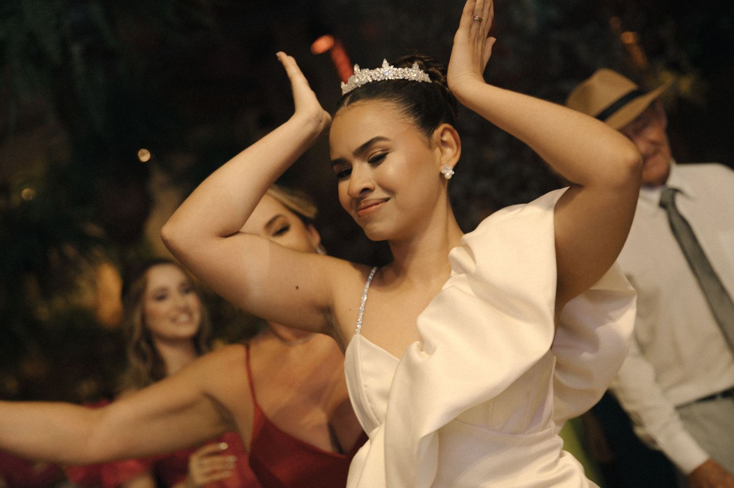 A group of dancers perform at a wedding reception, moving in sync on the dance floor.