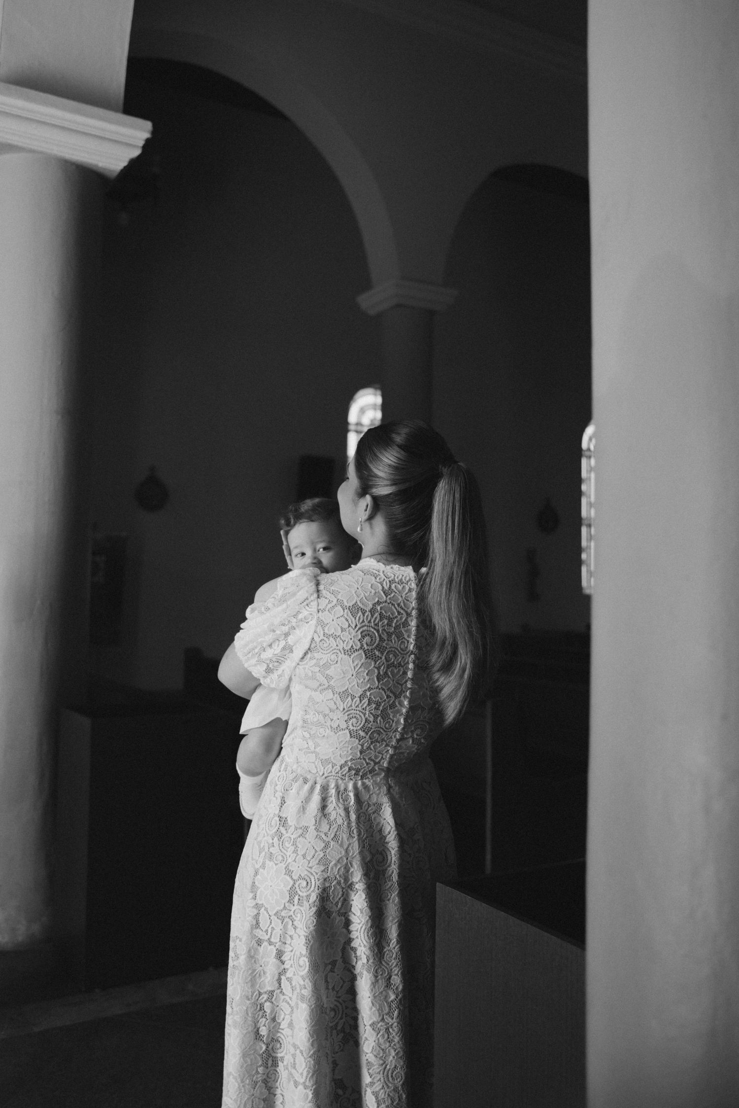 A series of black and white photos showing a couple in an intimate moment against a dark interior wall.