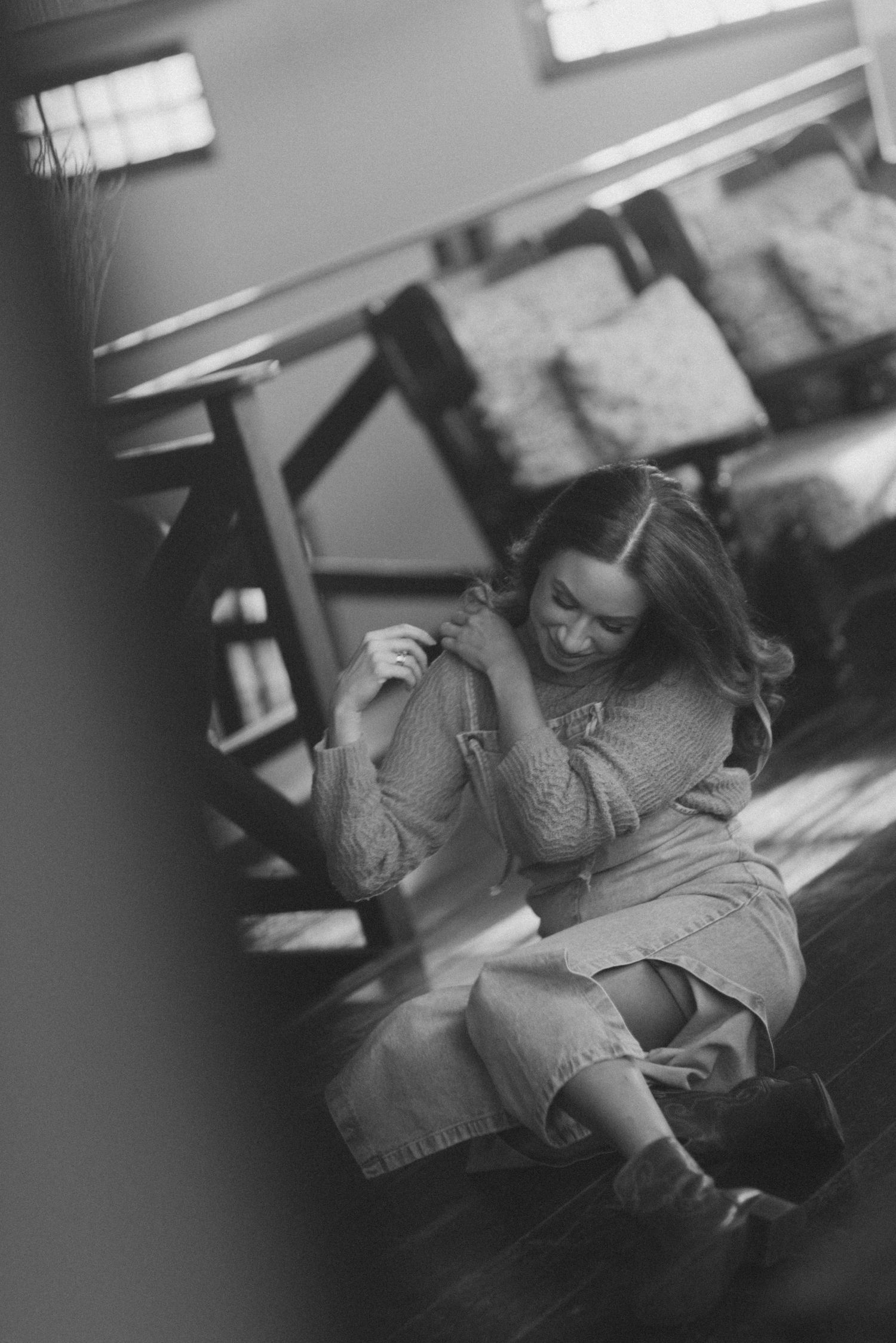 Artistic black and white photo showing a relaxed pose in casual clothing.