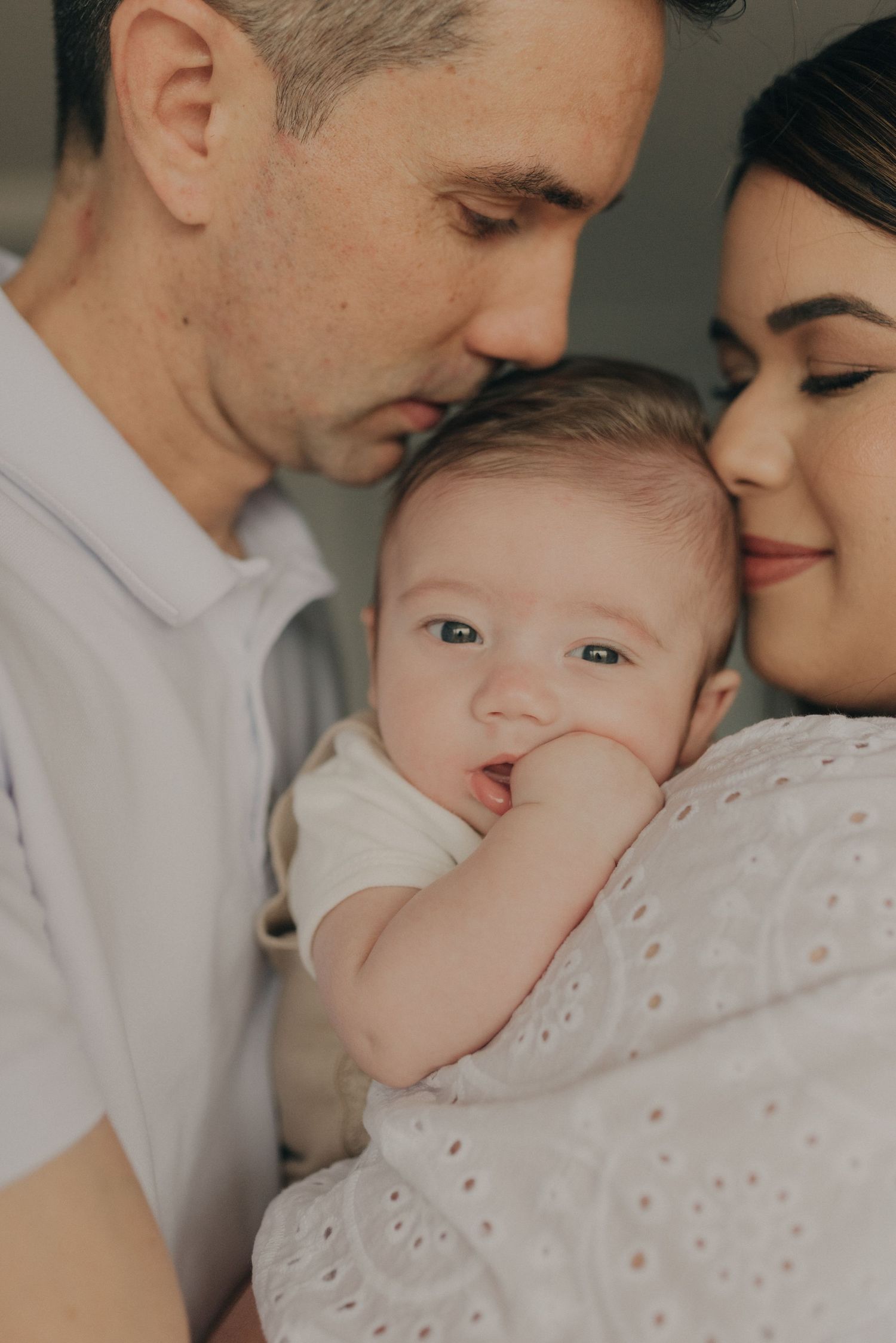 An intimate indoor family portrait showing gentle expressions and tender moments.