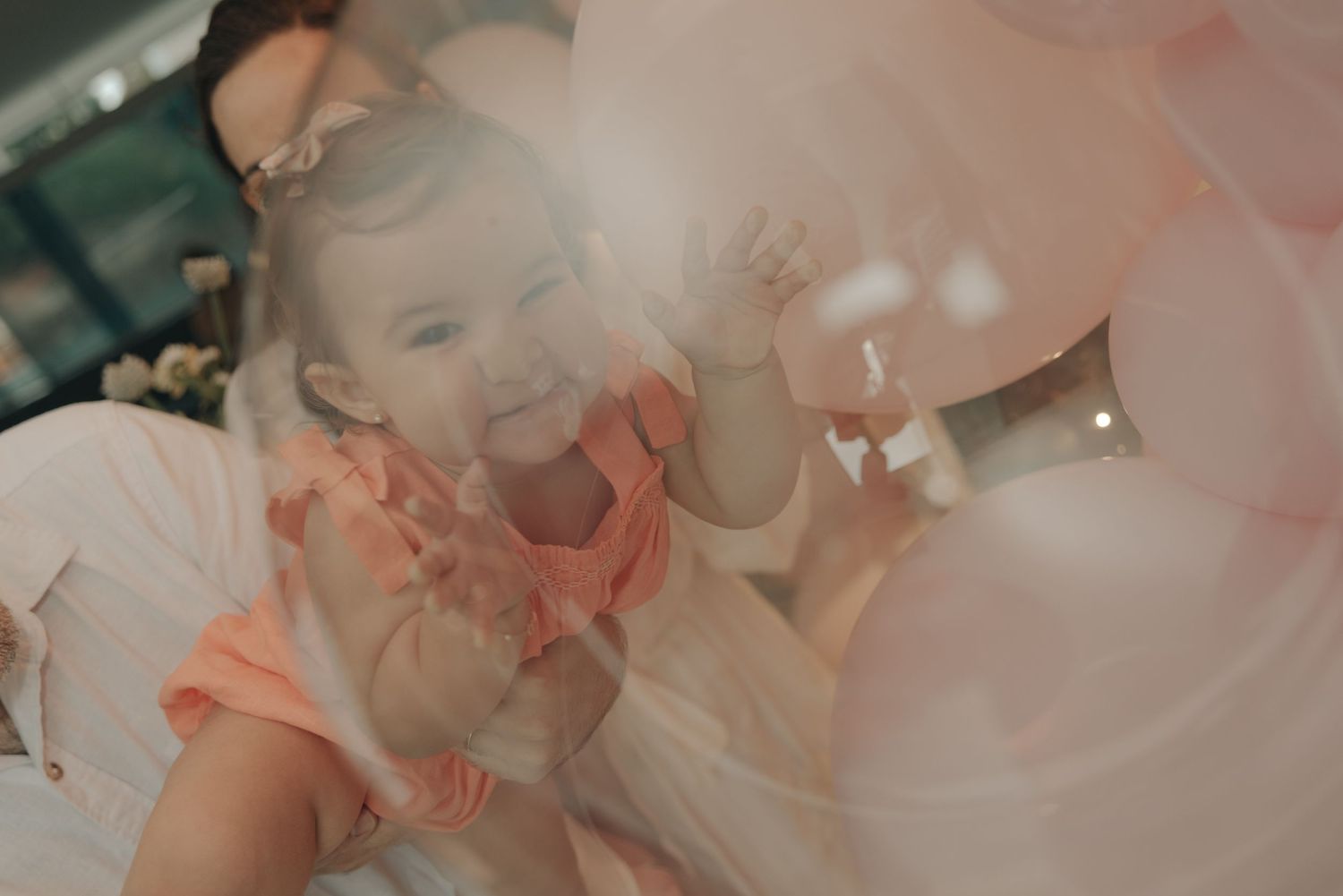 Dreamy scene with pink balloons and soft lighting at a celebration.