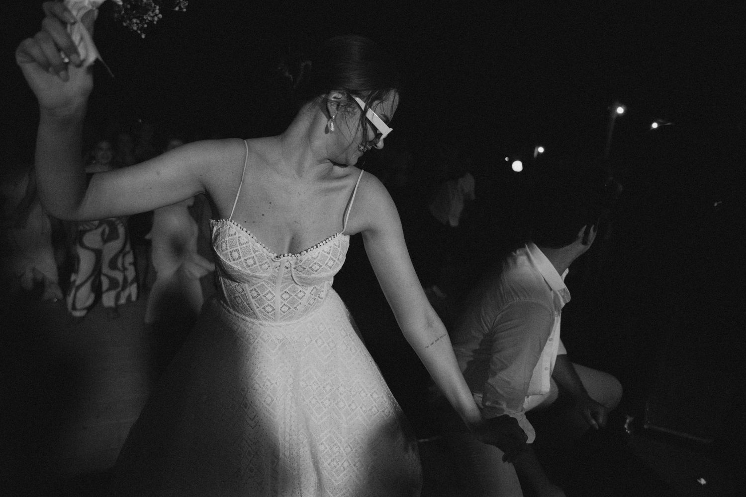 A festive dance celebration with people in formal attire dancing under dim lighting.