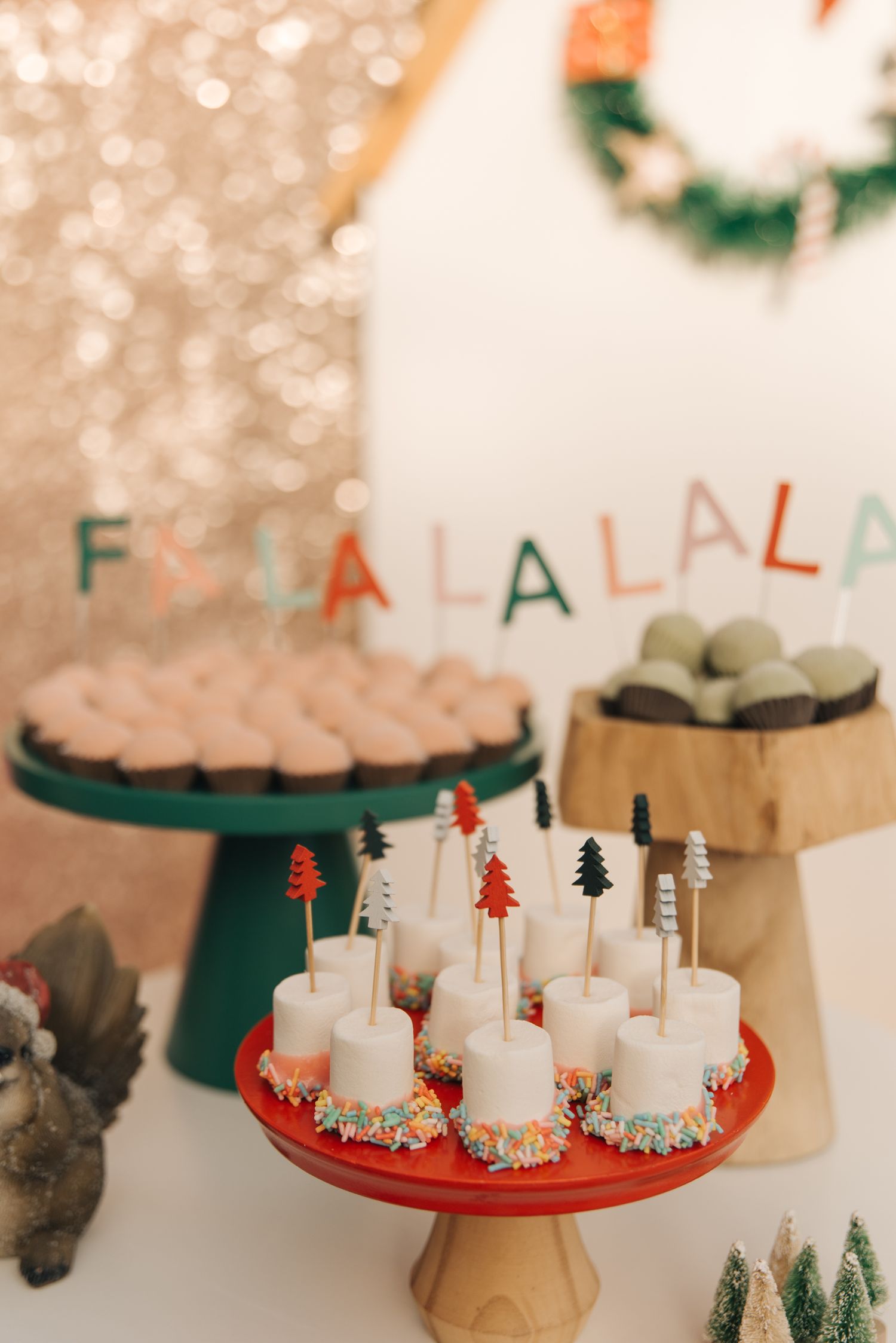 Holiday dessert table with white candies and FA LA LA LA letters displayed.
