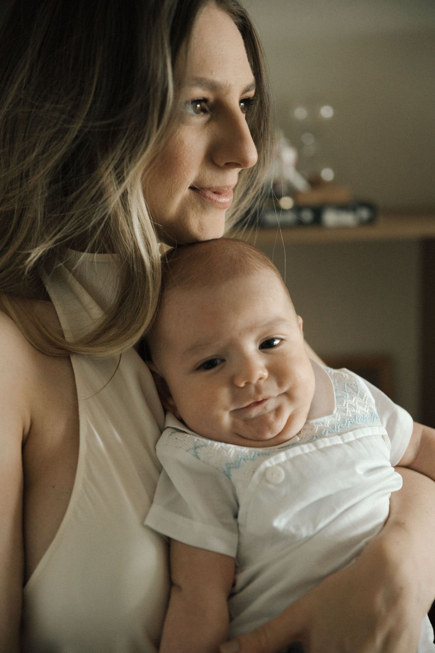 Tender moments captured in warm lighting showing parent and infant bonding together.