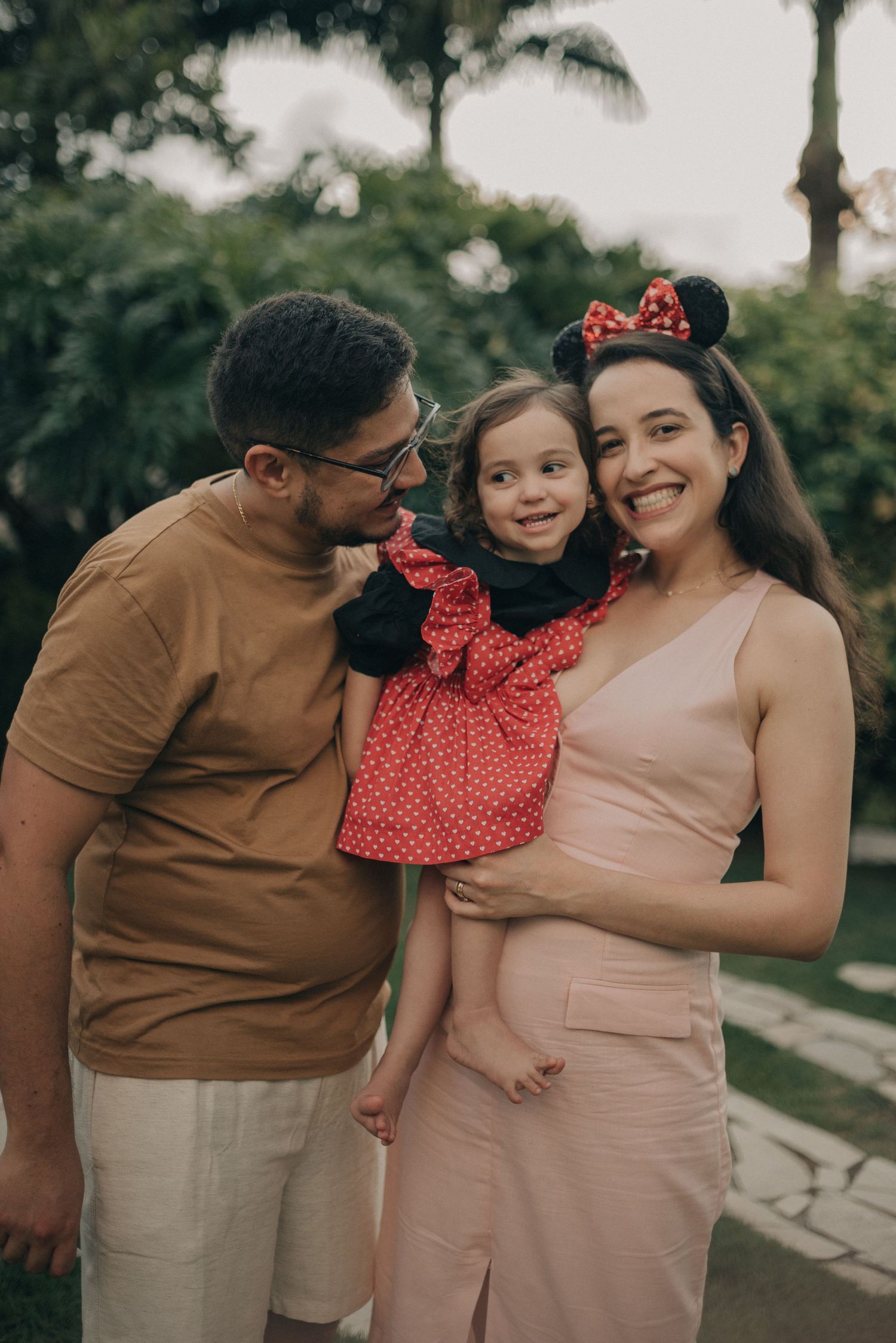 Family dressed in coordinated outfits posing together outdoors.