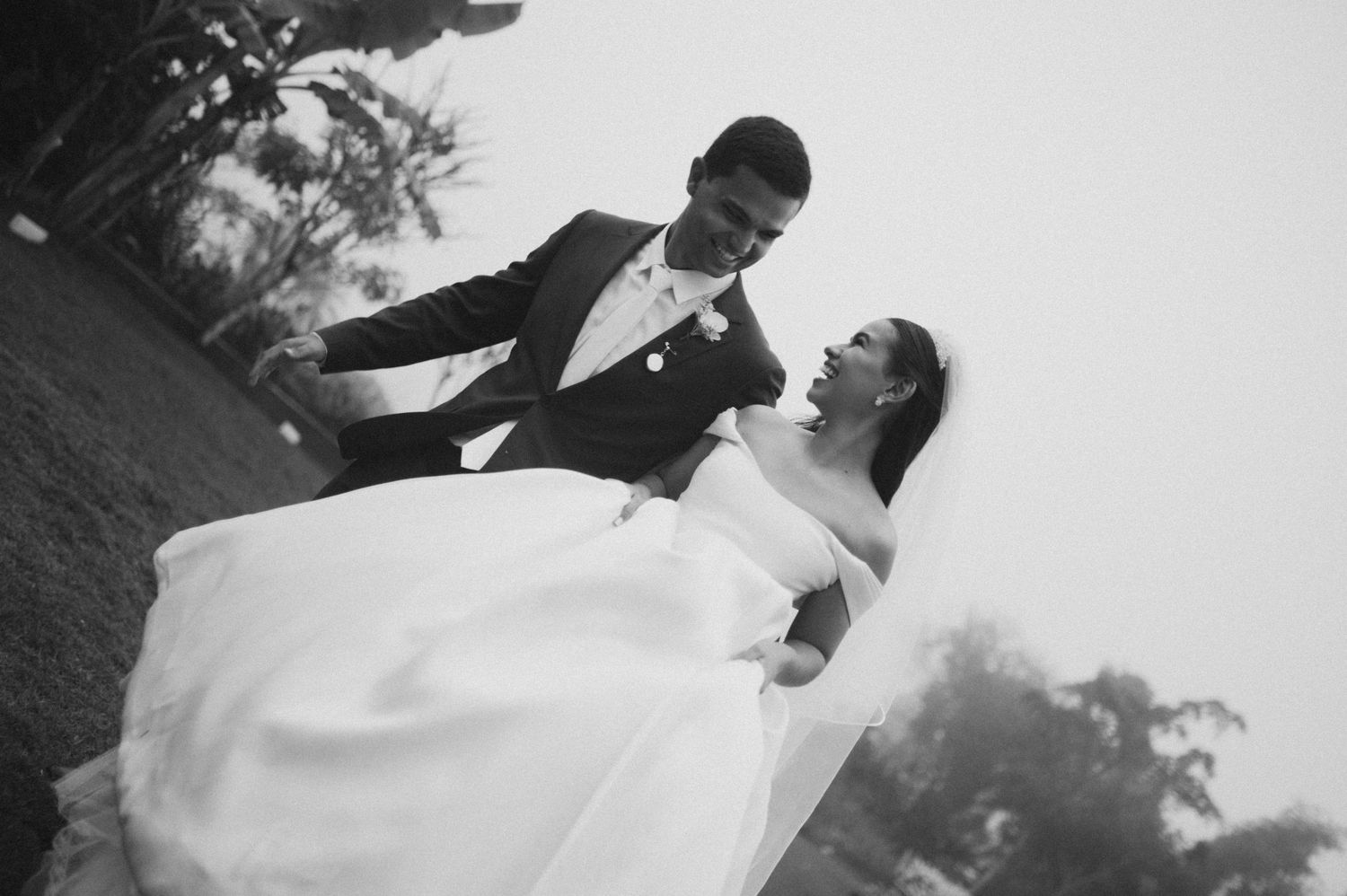 A romantic black and white photo series showing newlyweds embracing and dancing during their wedding celebration.