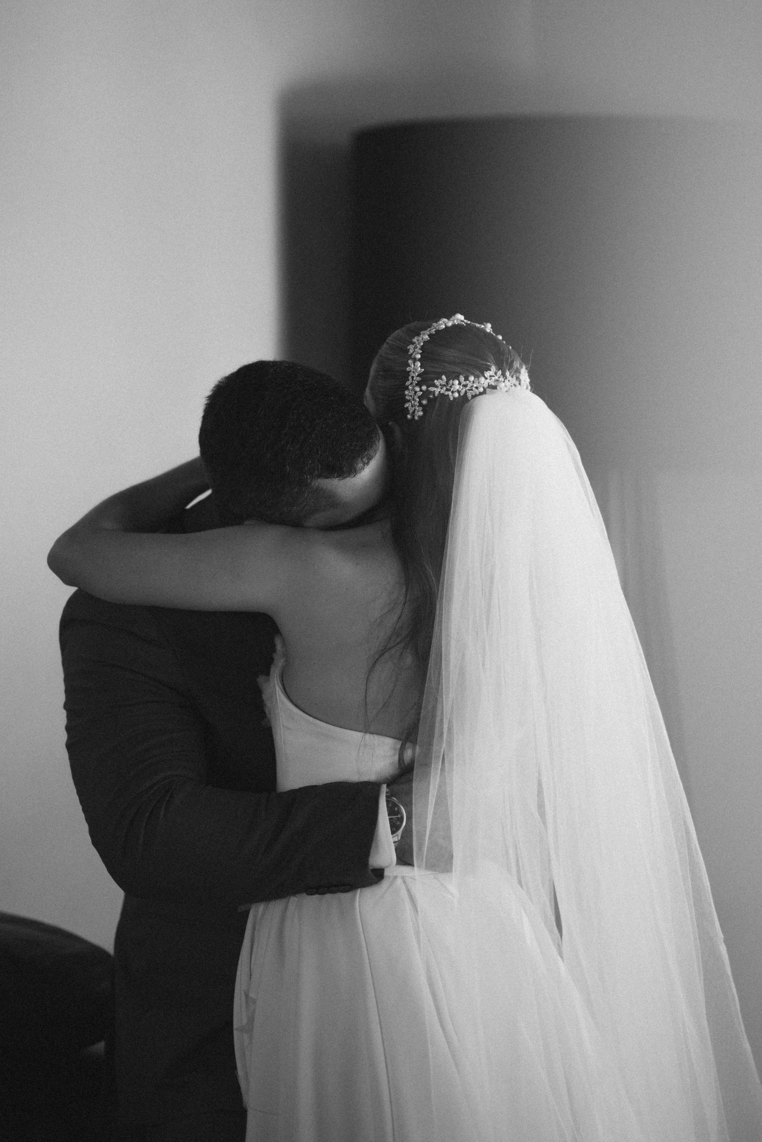 Intimate black and white portrait of a tender embrace between newlyweds.