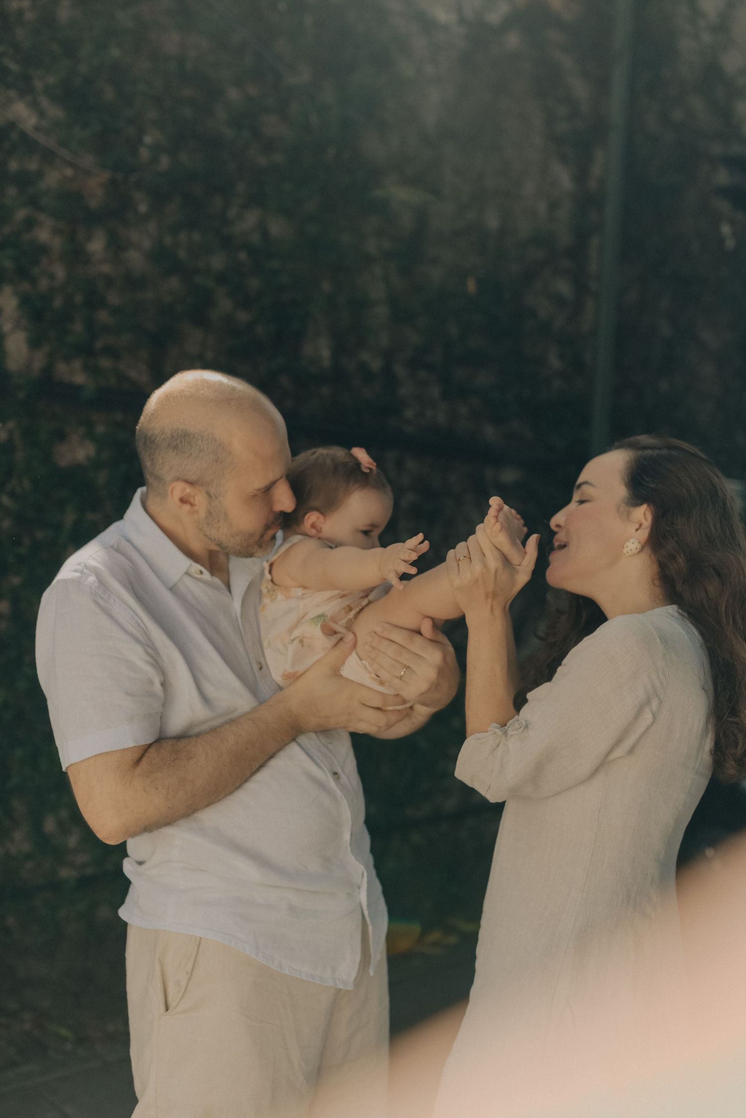 Candid outdoor family moment filled with laughter and joy in warm sunlight.