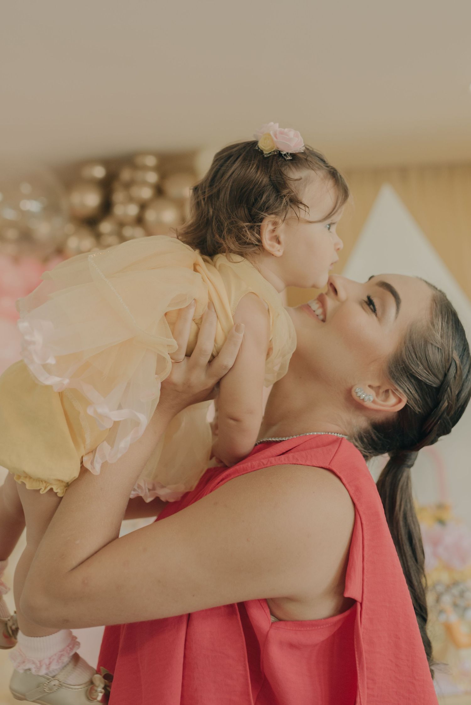 A tender moment captured during a celebration with coral and yellow tones.