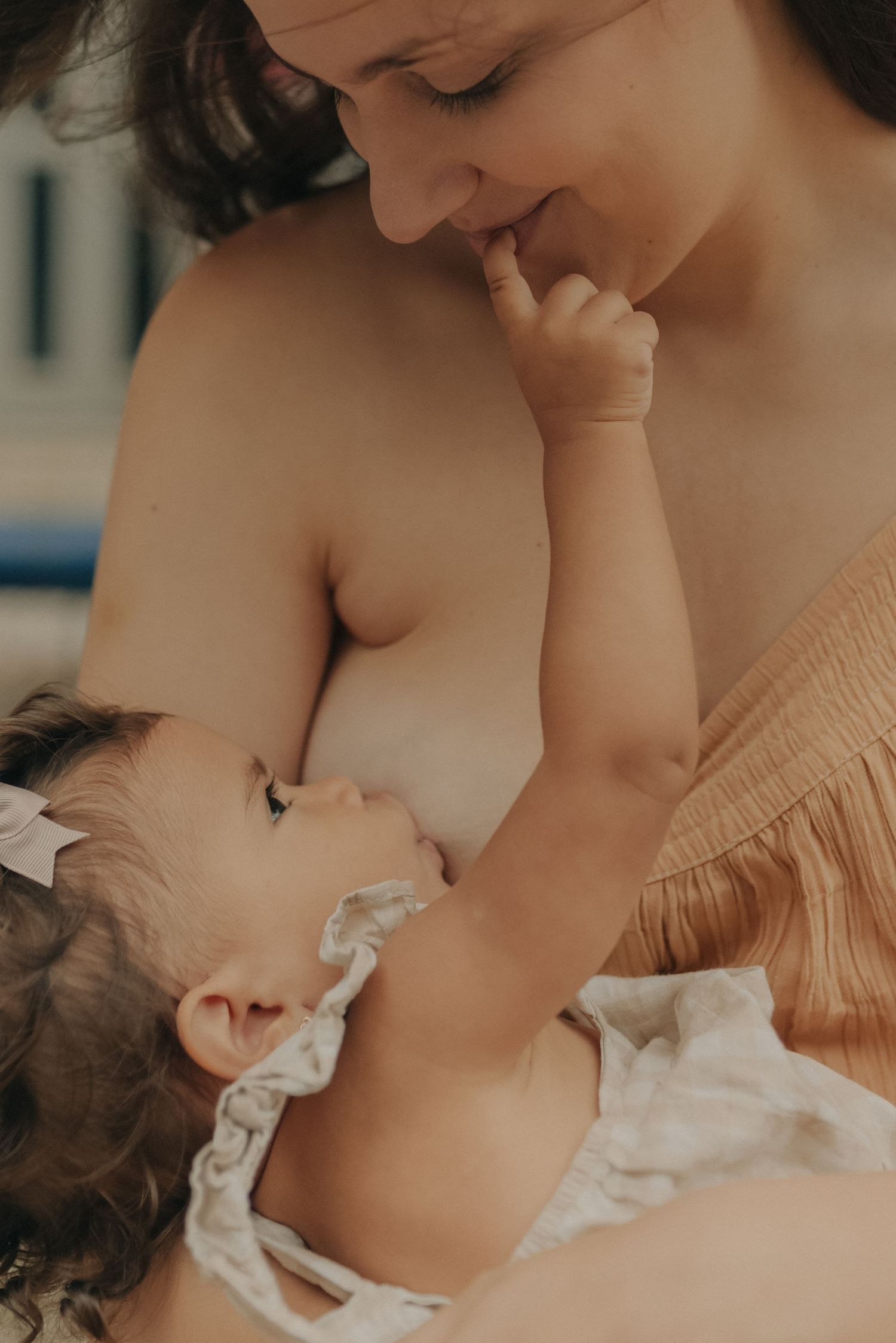 An intimate moment between parent and baby as they share a tender connection in warm lighting.