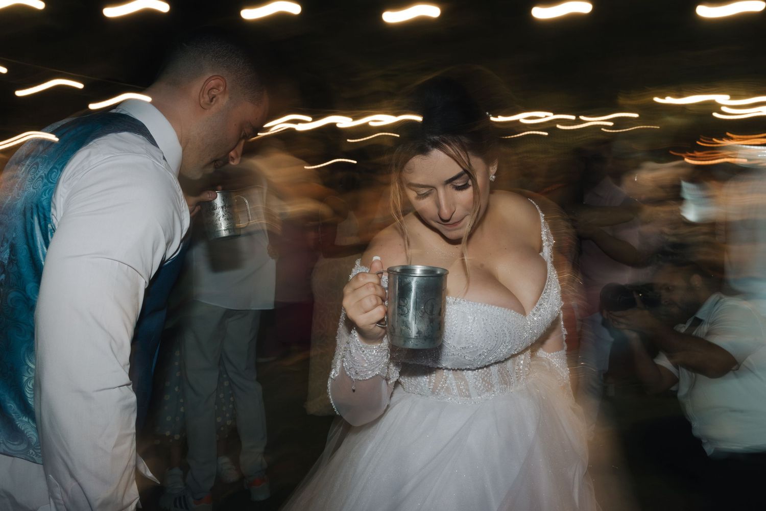 A blurred motion shot of dancing at a wedding reception with dramatic lighting.