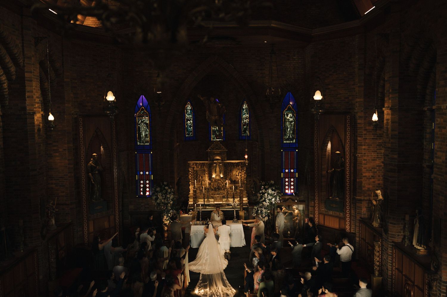 Interior view of a historic church with stained glass windows and ornate architectural details illuminated by soft lighting.