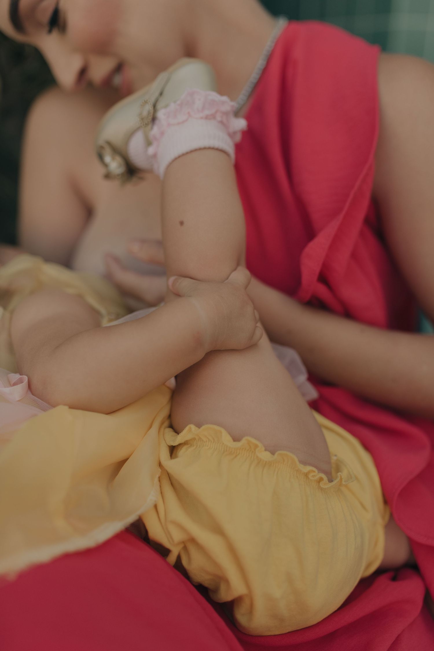 A gentle moment captured in soft lighting with coral and yellow tones.