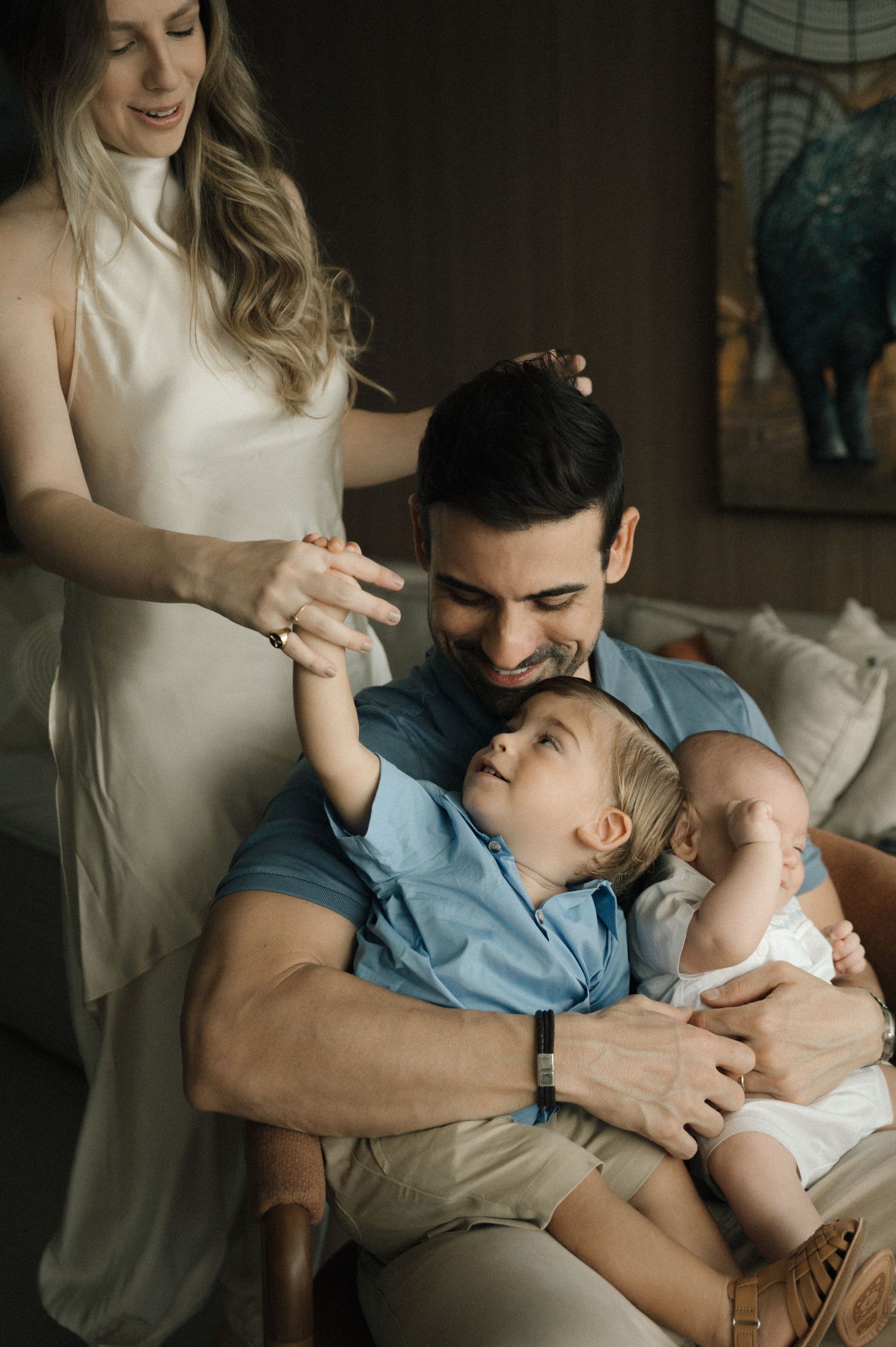 A tender family moment captured in a series of intimate lifestyle photographs showing parents bonding with their baby.