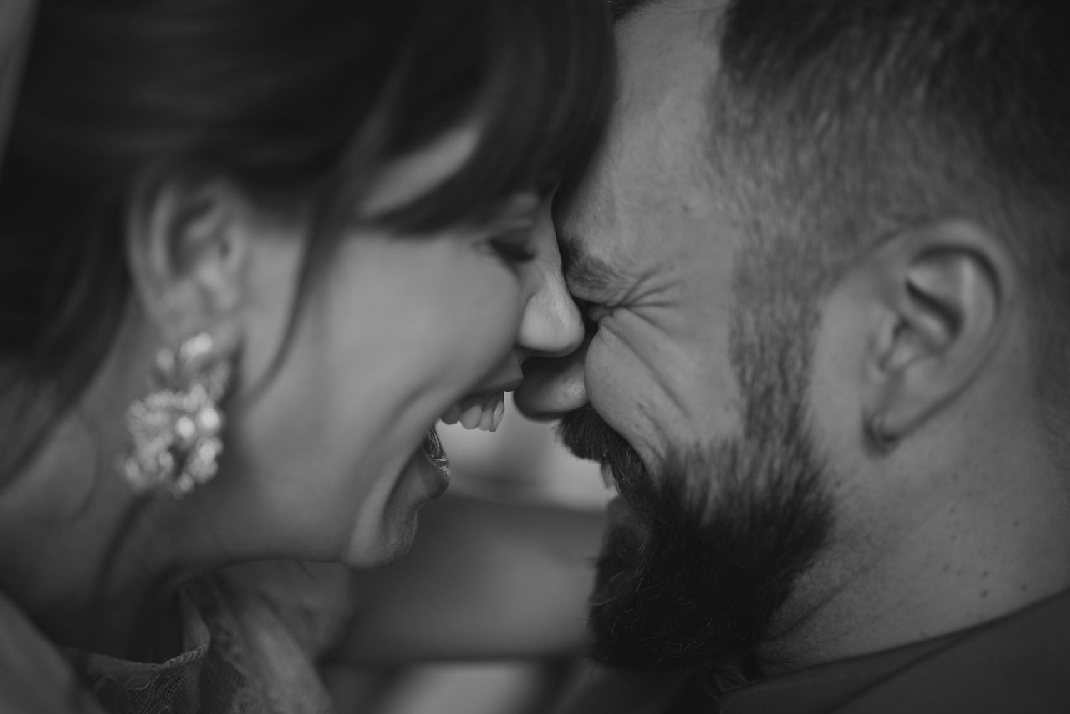 An intimate black and white close-up of a couple sharing a joyful moment together.