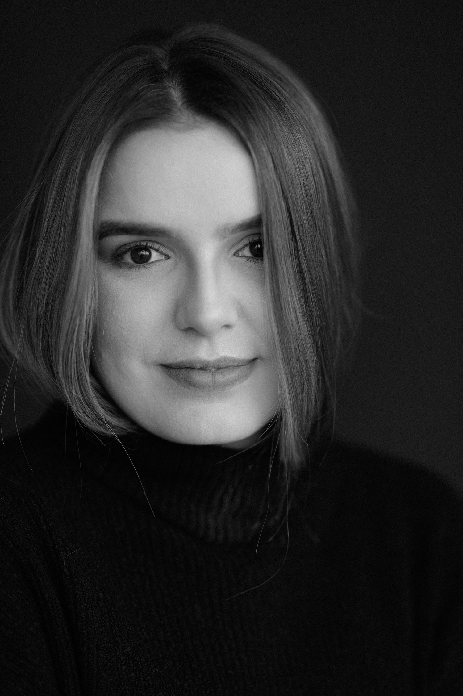 Classic black and white portrait with turtleneck sweater and natural lighting.