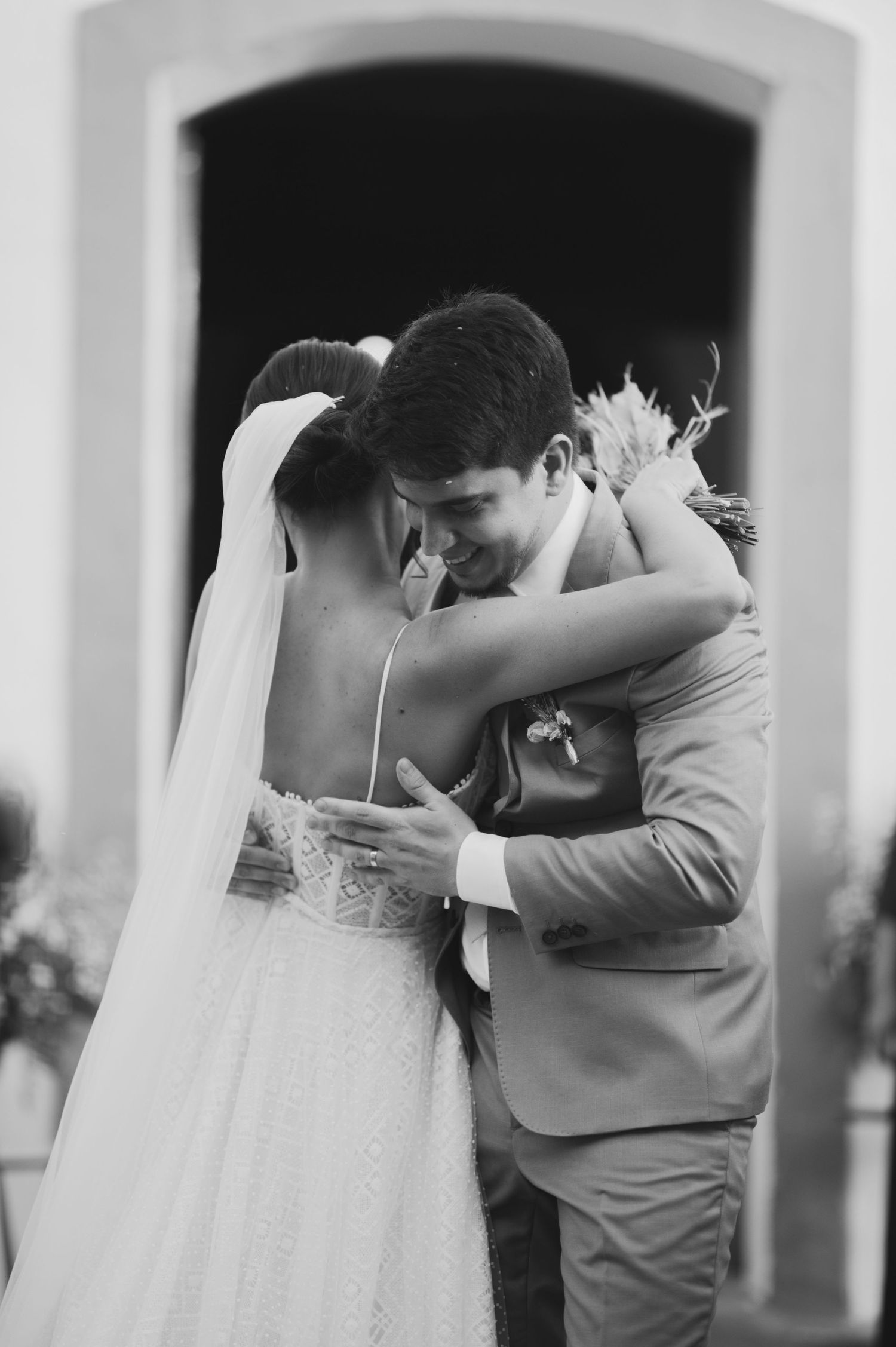 Black and white photo of an intimate embrace between newlyweds.