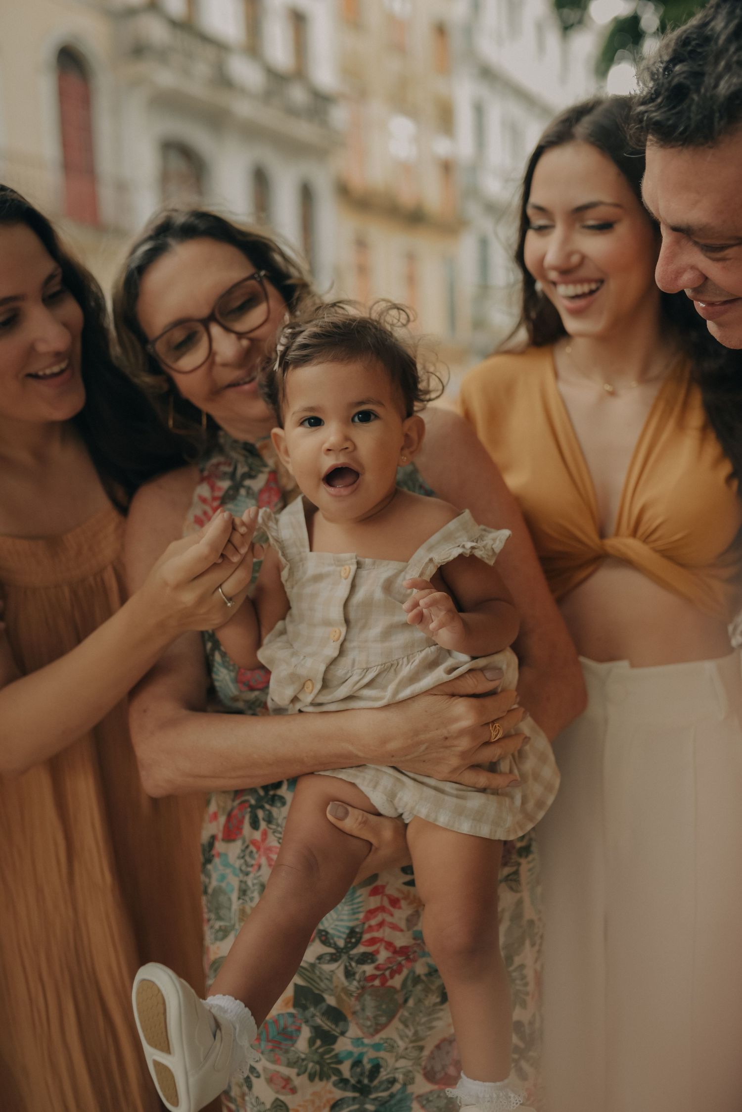 Group enjoying a celebratory moment with a baby in a beautiful urban setting.
