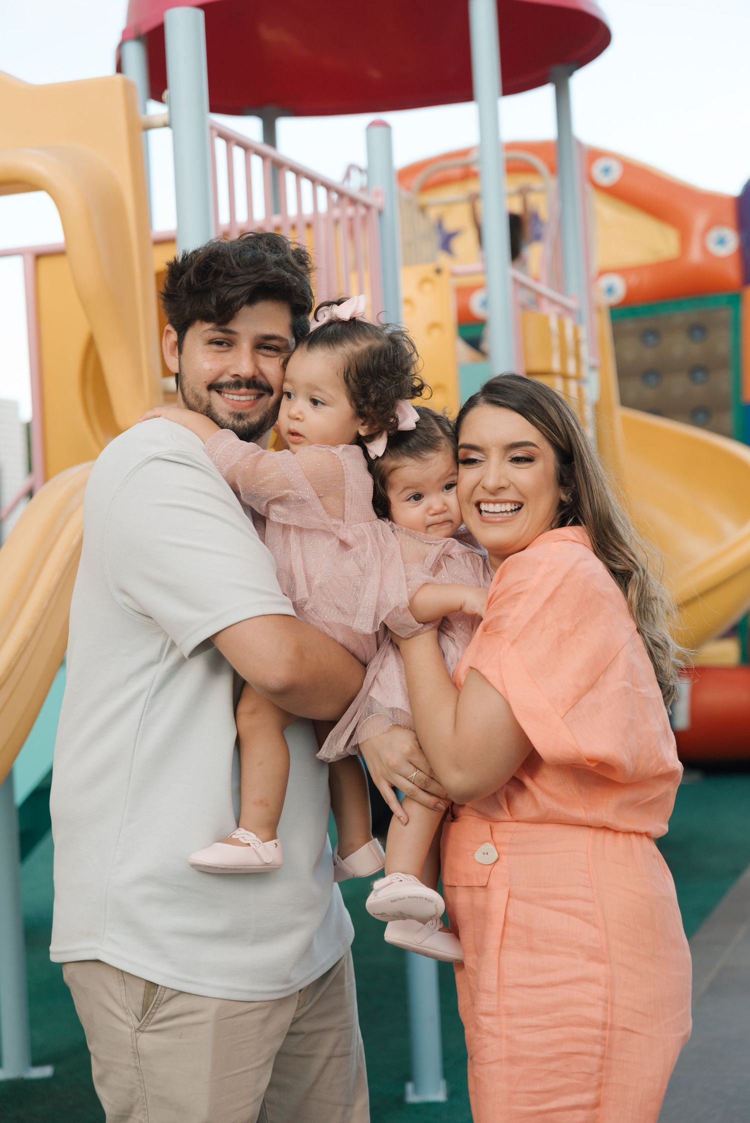 Family enjoying time together at a colorful outdoor playground.
