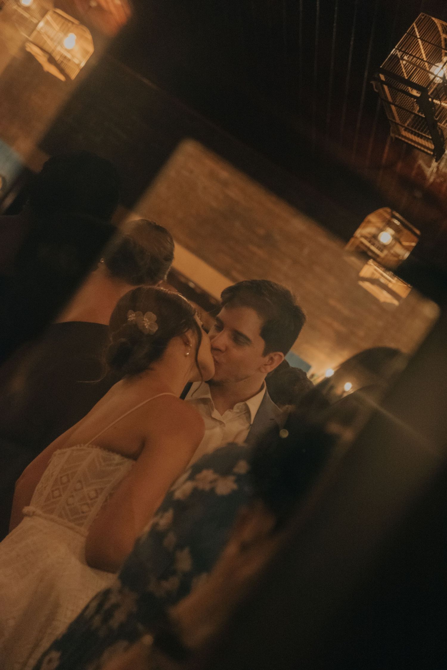 Intimate candlelit wedding moment with couple sharing a dance in warm lighting.