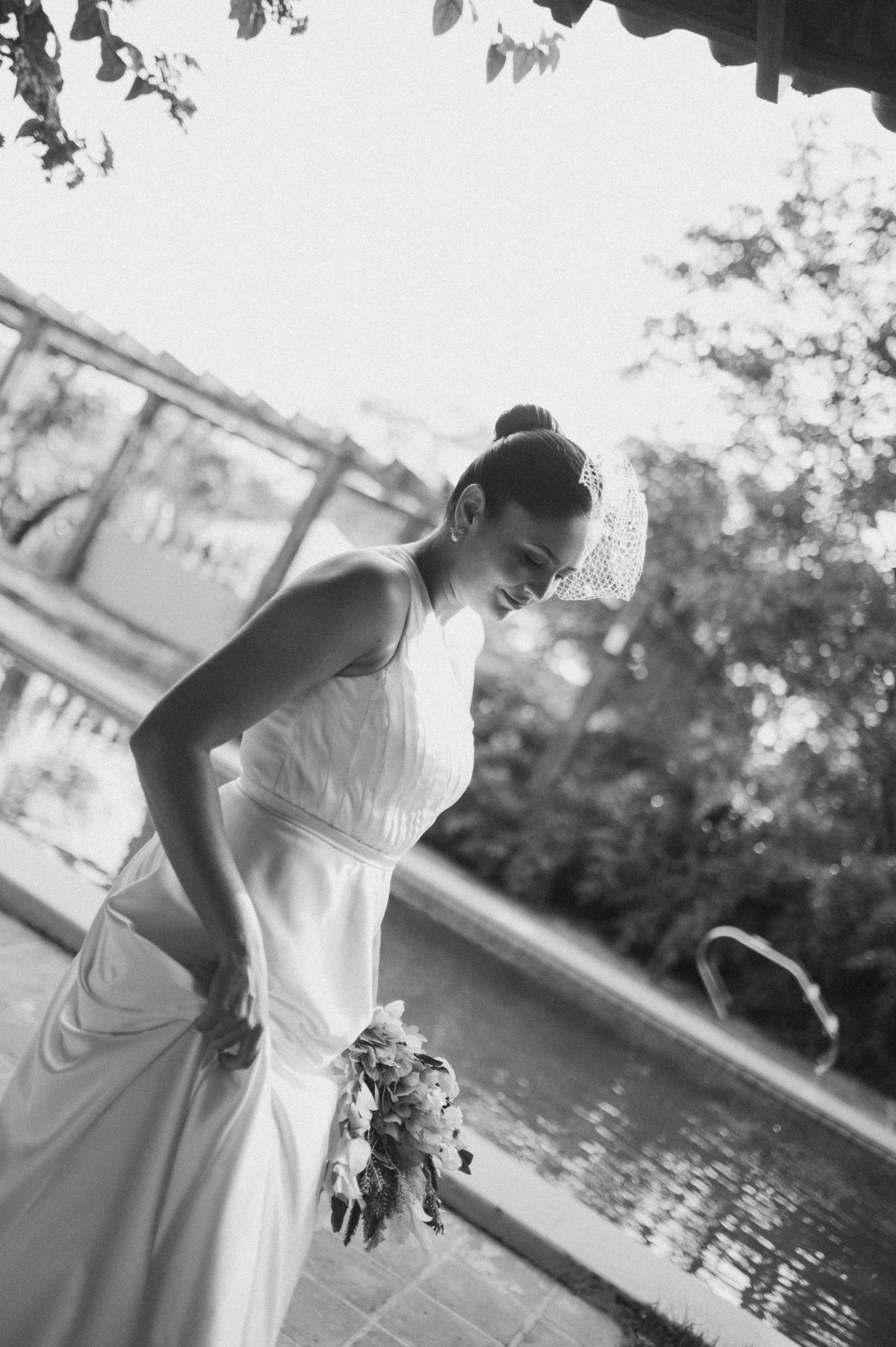 Black and white wedding photography sequence capturing romantic moments by a reflective water feature.