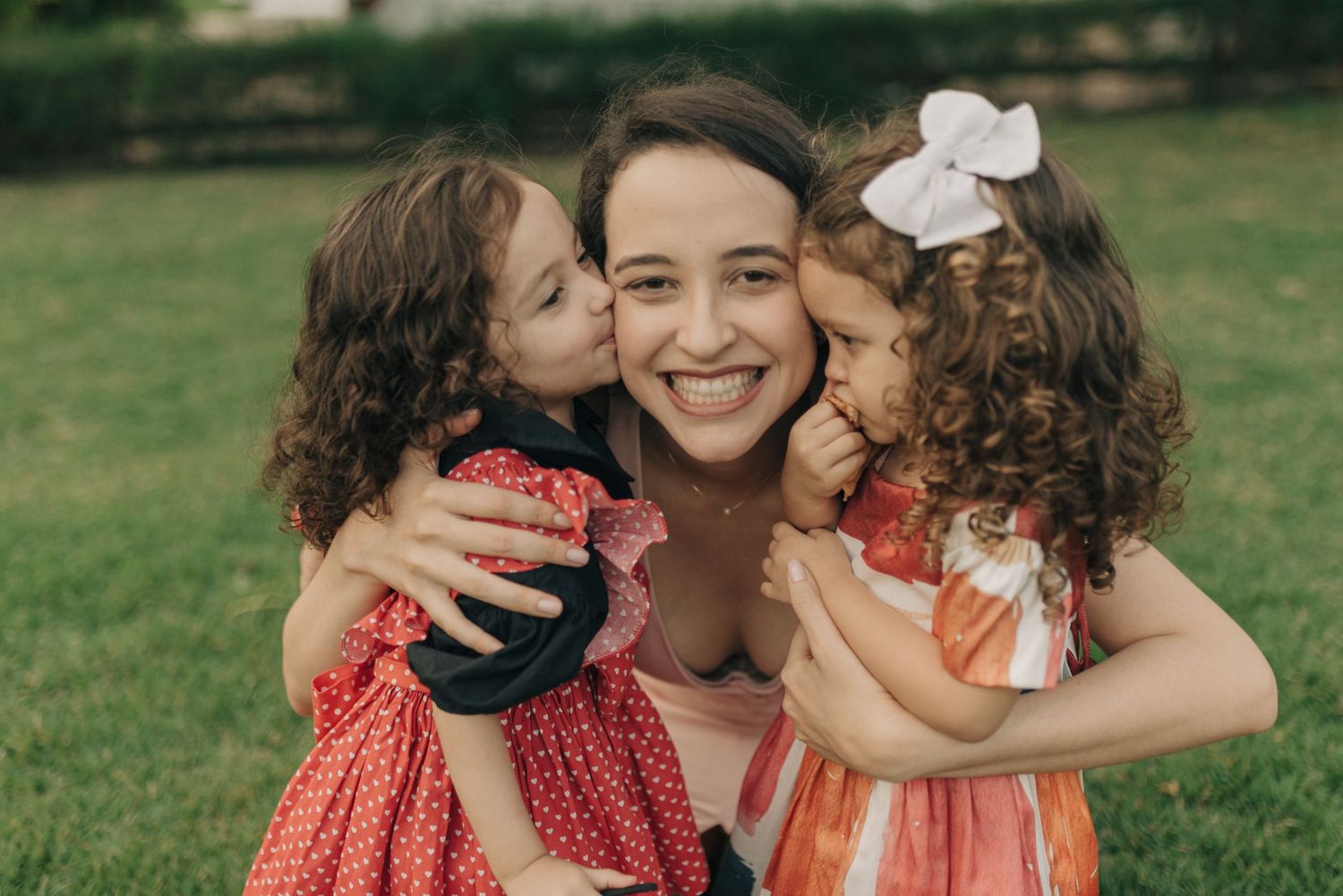 Joyful outdoor family moment captured in natural sunlight on grass.