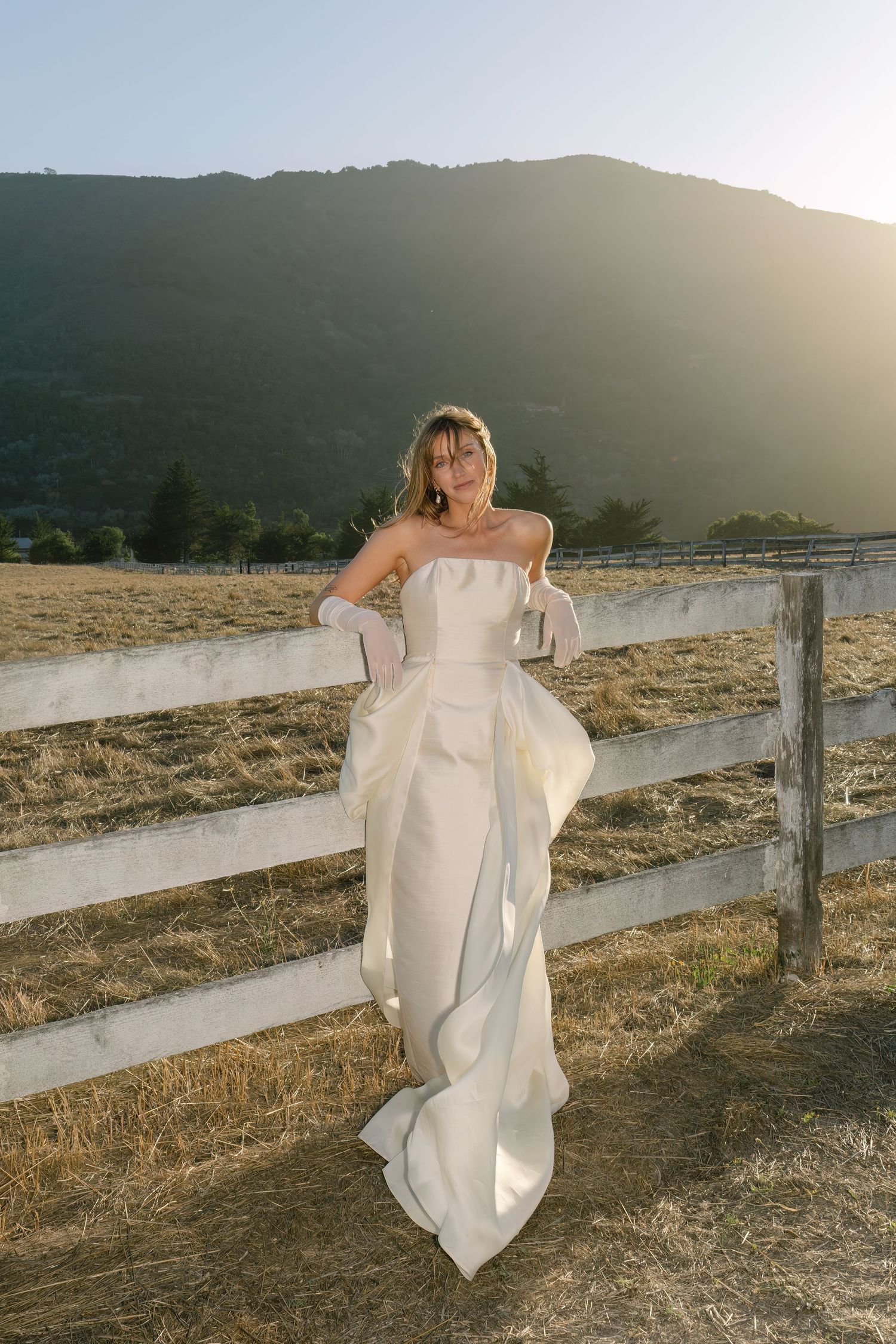 Flowing white wedding dress captured against a fence and golden sunset light captured on film by Danielle Conner Photography in Carmel.