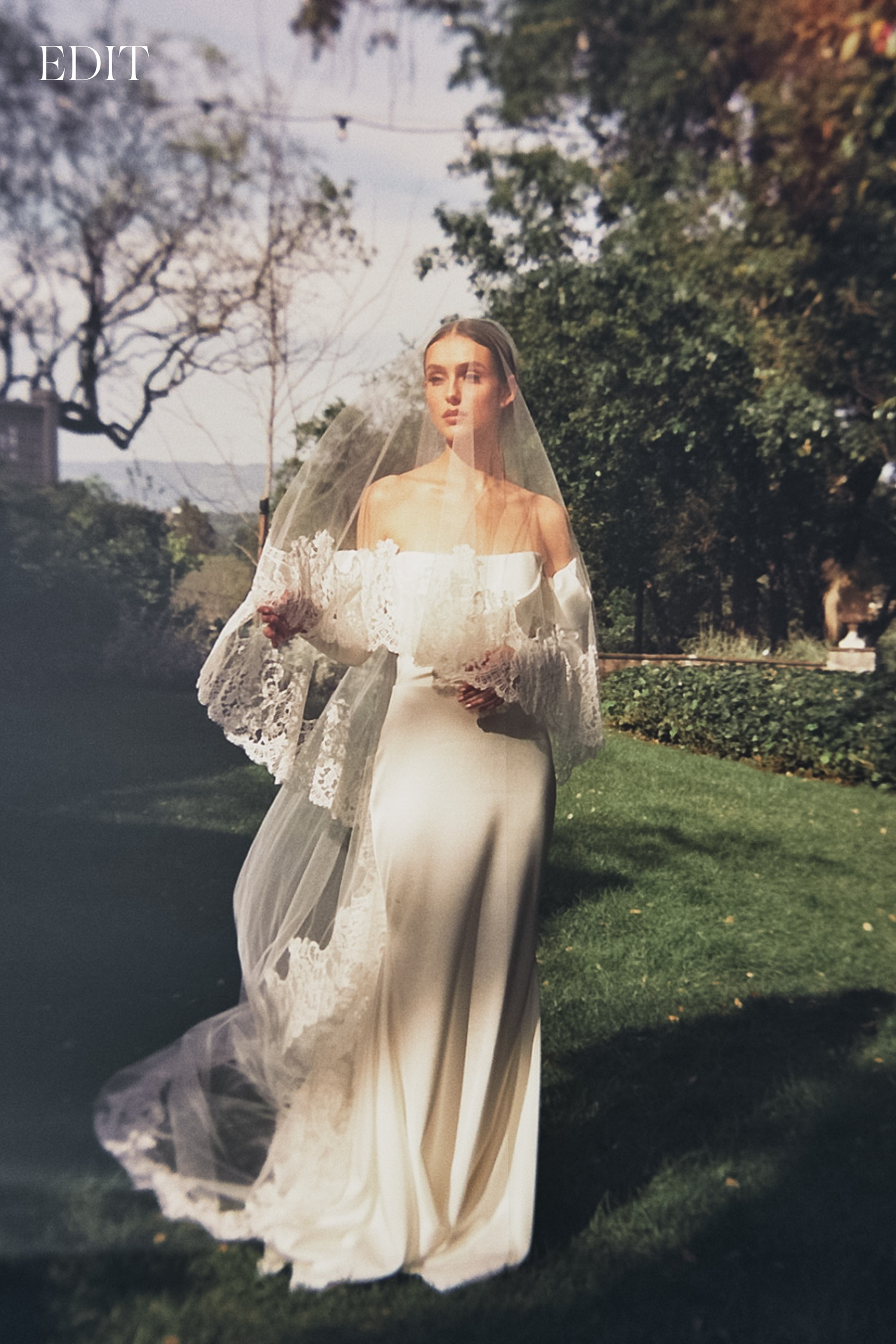 Ethereal bridal portraits in a garden setting featuring flowing off-shoulder gown and delicate veil.