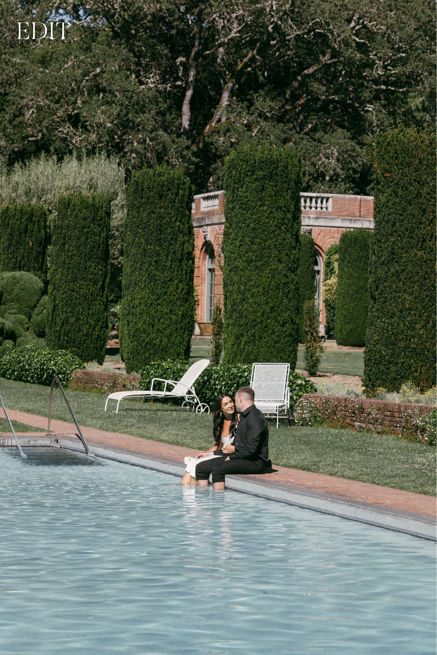 Sequence of someone falling into a swimming pool surrounded by manicured hedges.