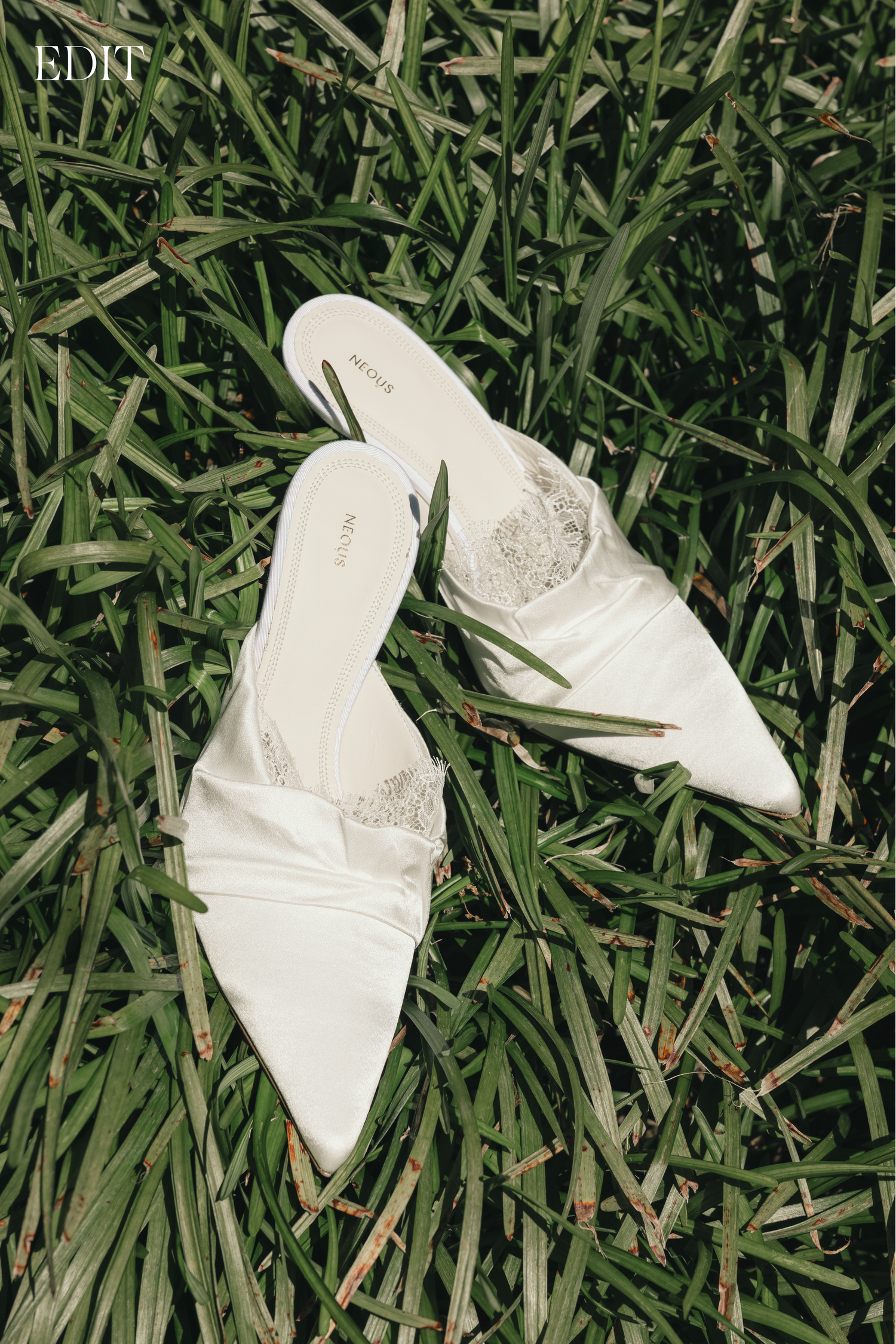 White bridal shoes arranged on green grass in natural lighting.