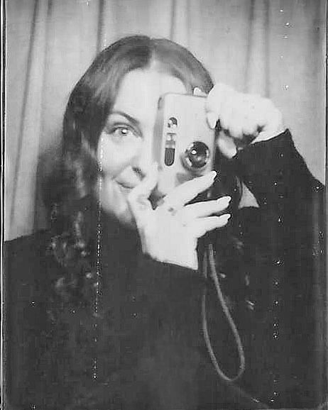 A vintage black and white photobooth-style portrait of Danielle Conner - California wedding photographer taking a picture with a filmcamera.